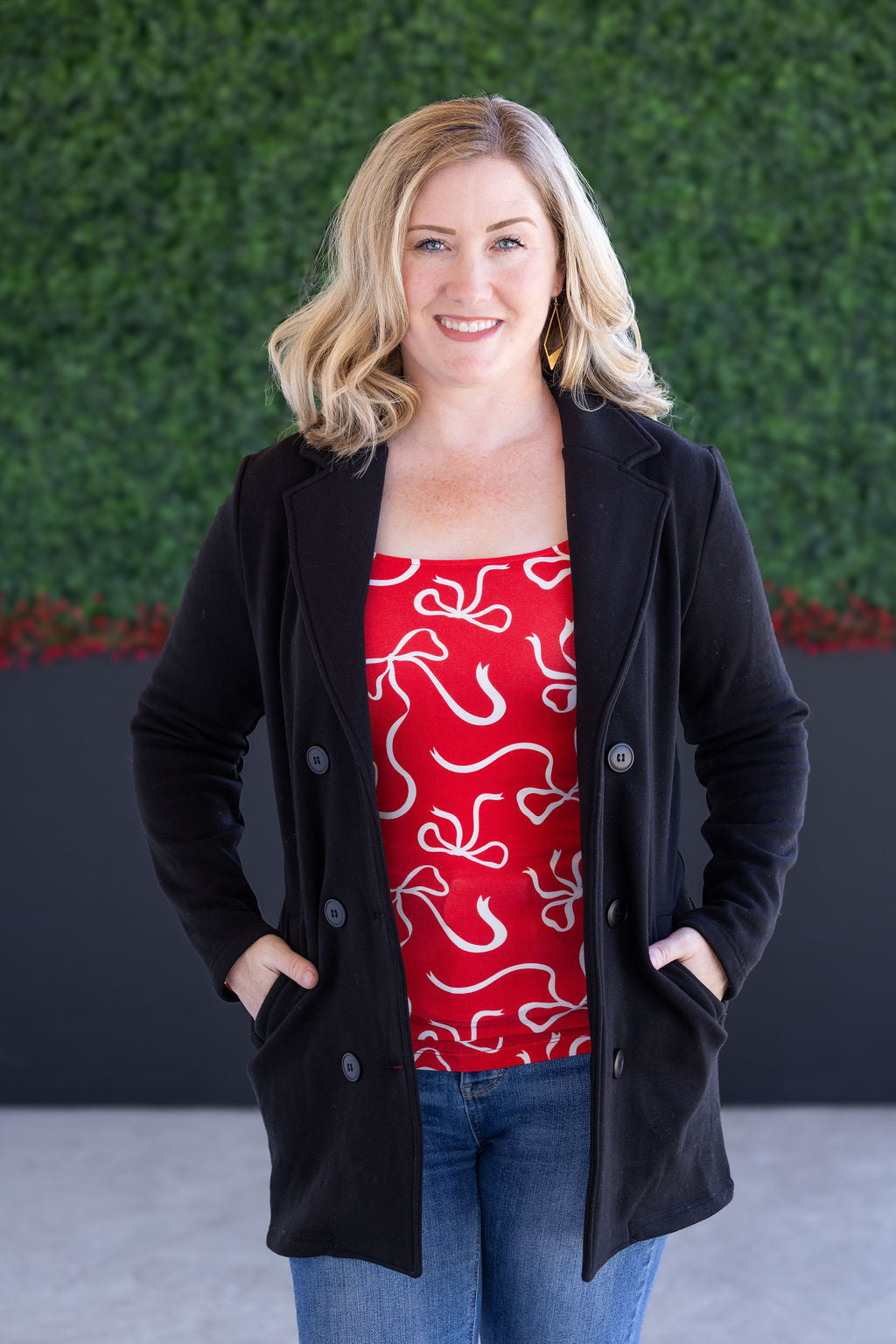 Woman wearing black sweater jacket with red top and jeans