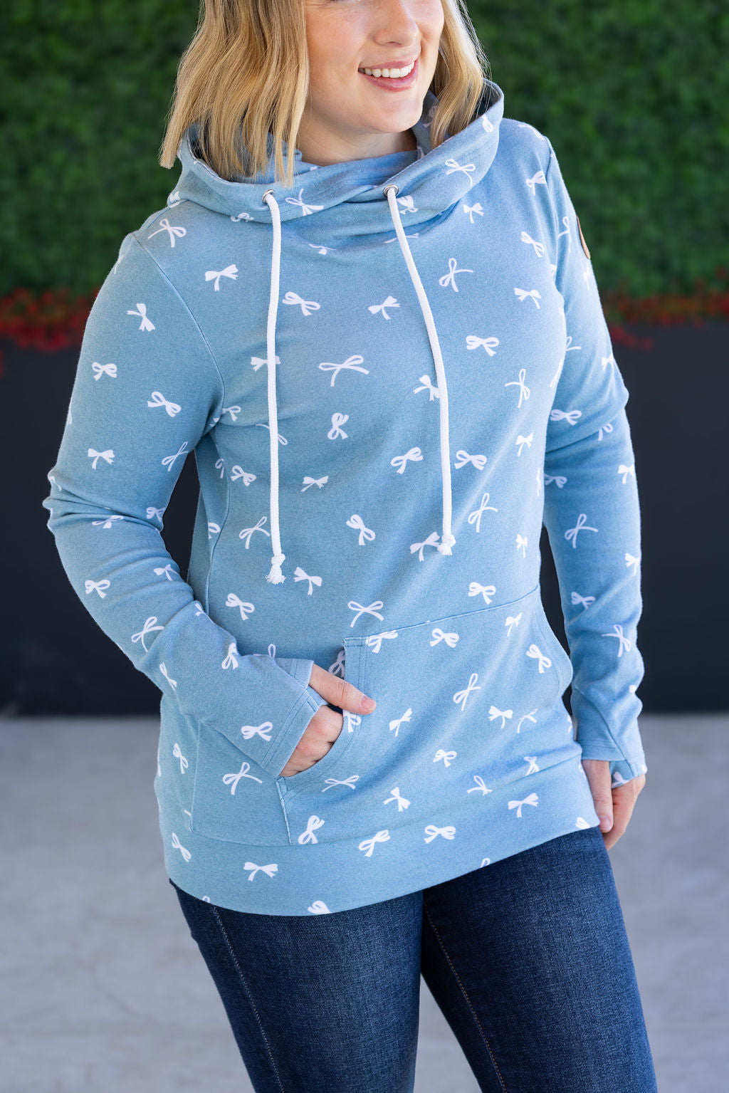 Woman wearing teal ribbons hoodie with pockets and jeans