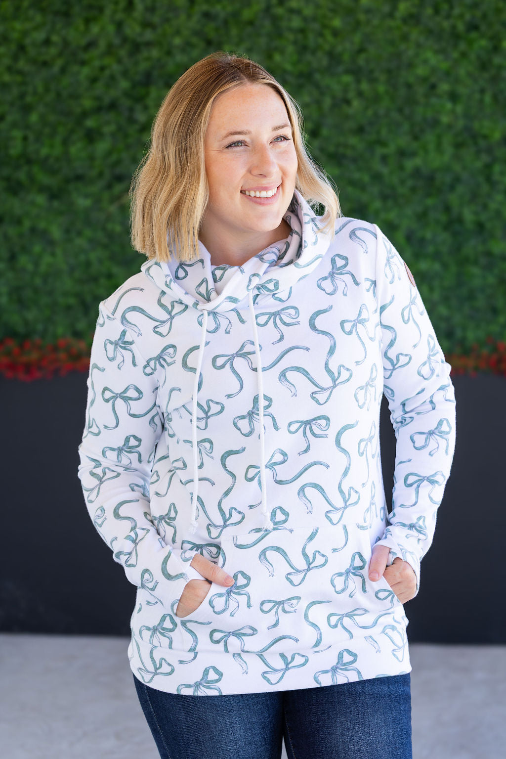 Woman wearing green ribbons hoodie with pockets and jeans