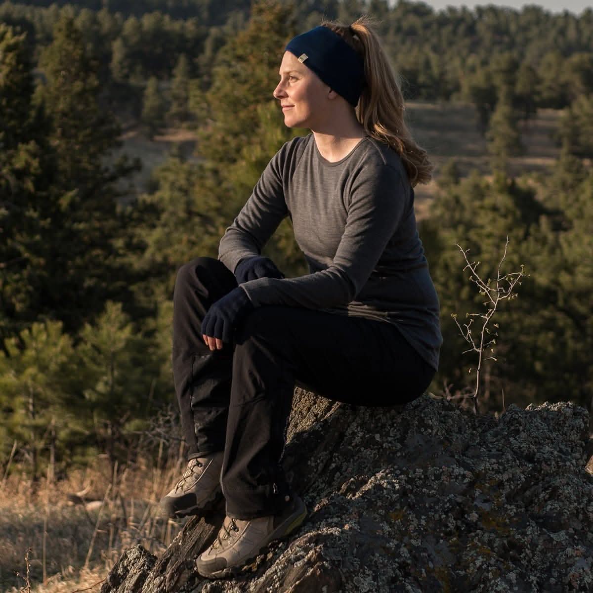Person sitting on a rock in a forested area