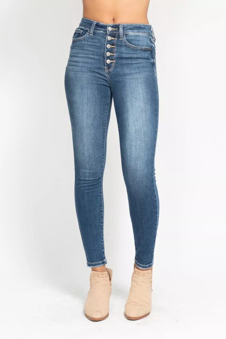 Woman wearing Elodie medium wash high rise button fly skinny jeans with exposed button fly and ankle length