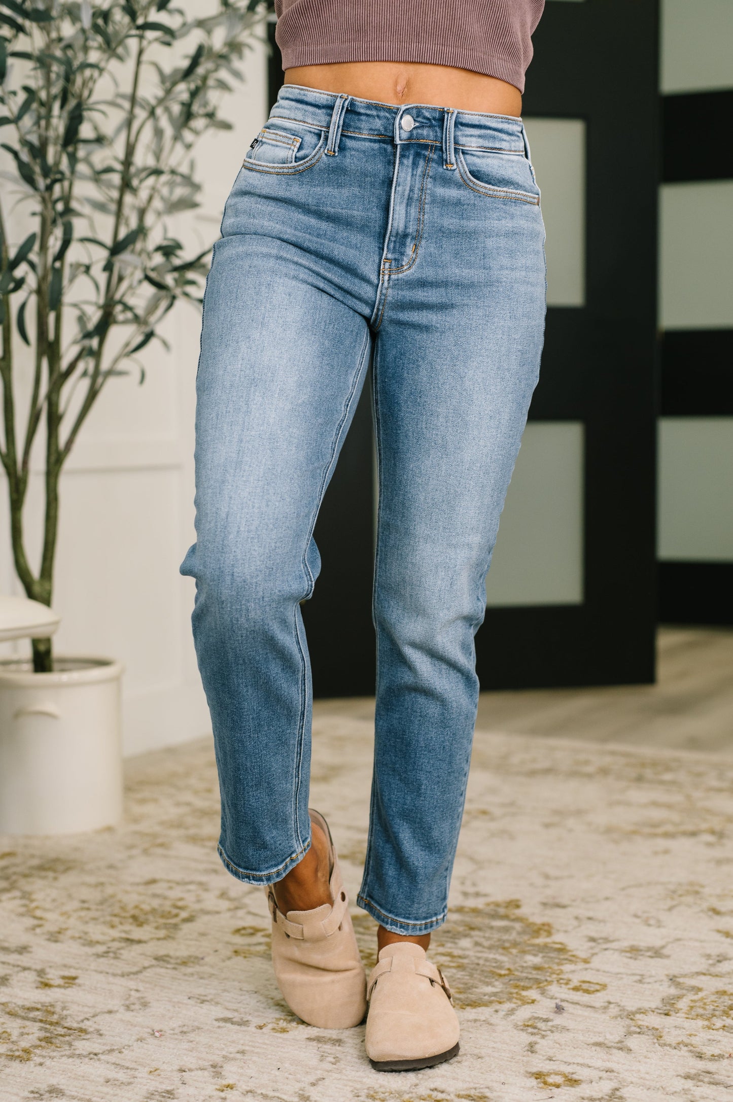  High waist ankle straight jeans in light wash denim with clean hem and classic five-pocket styling paired with mauve top and tan clogs