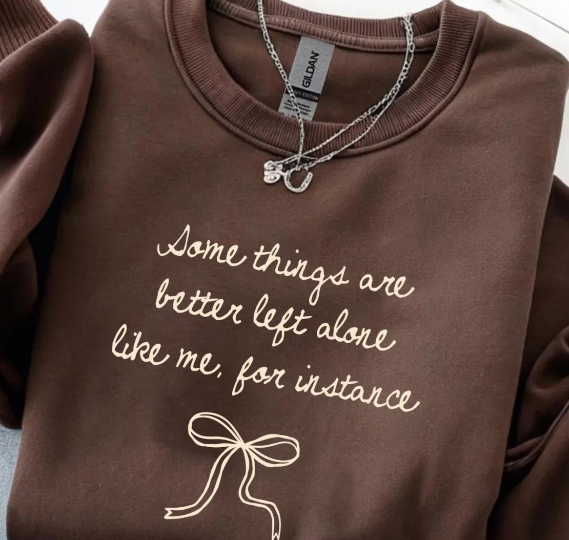 Women's graphic sweatshirt in Dark Chocolate with "Some things are better left alone like me, for instance" text in cream script with bow illustration