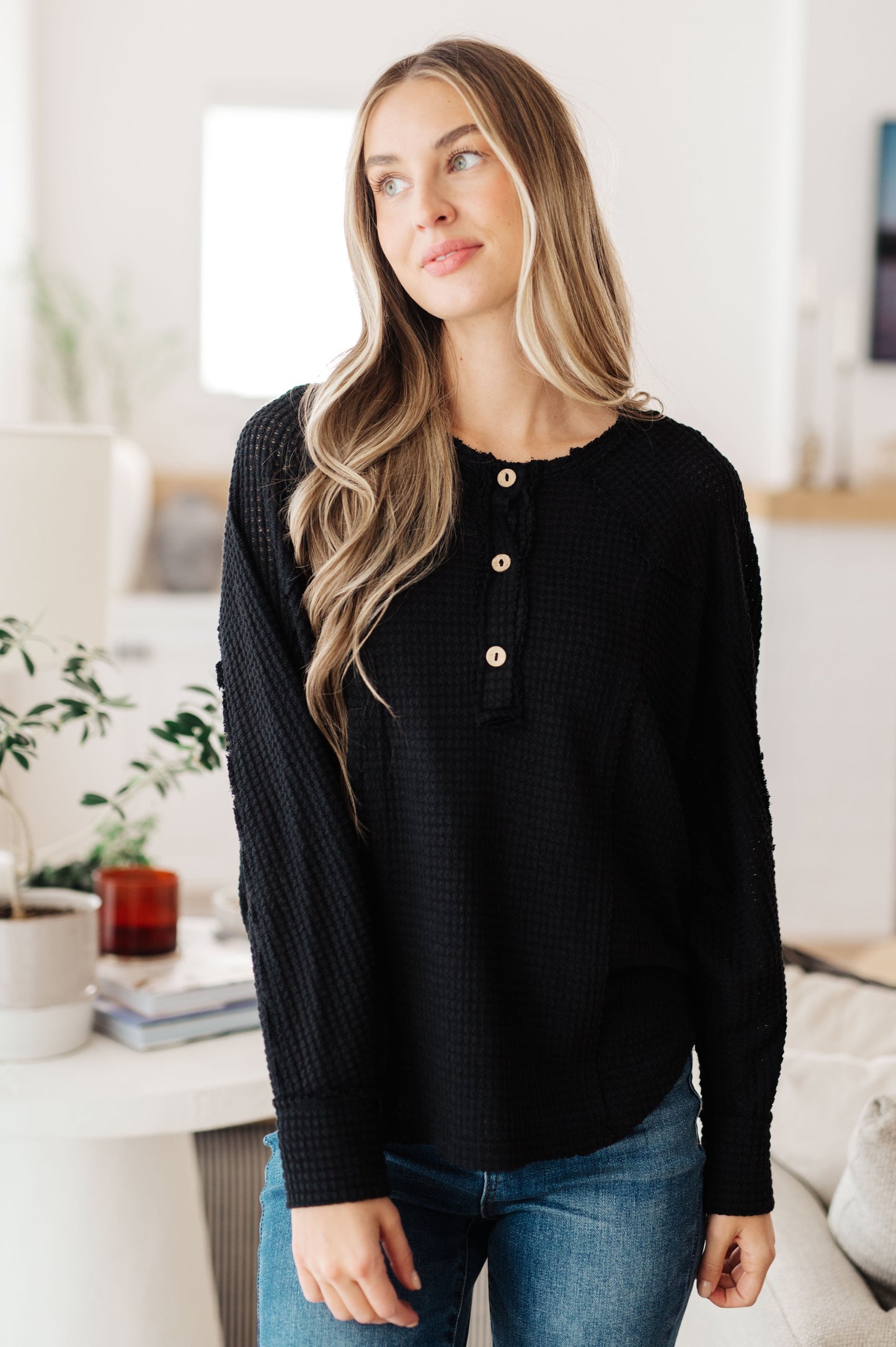 Model wearing the Better than Best Henley Top in black waffle knit with wooden buttons