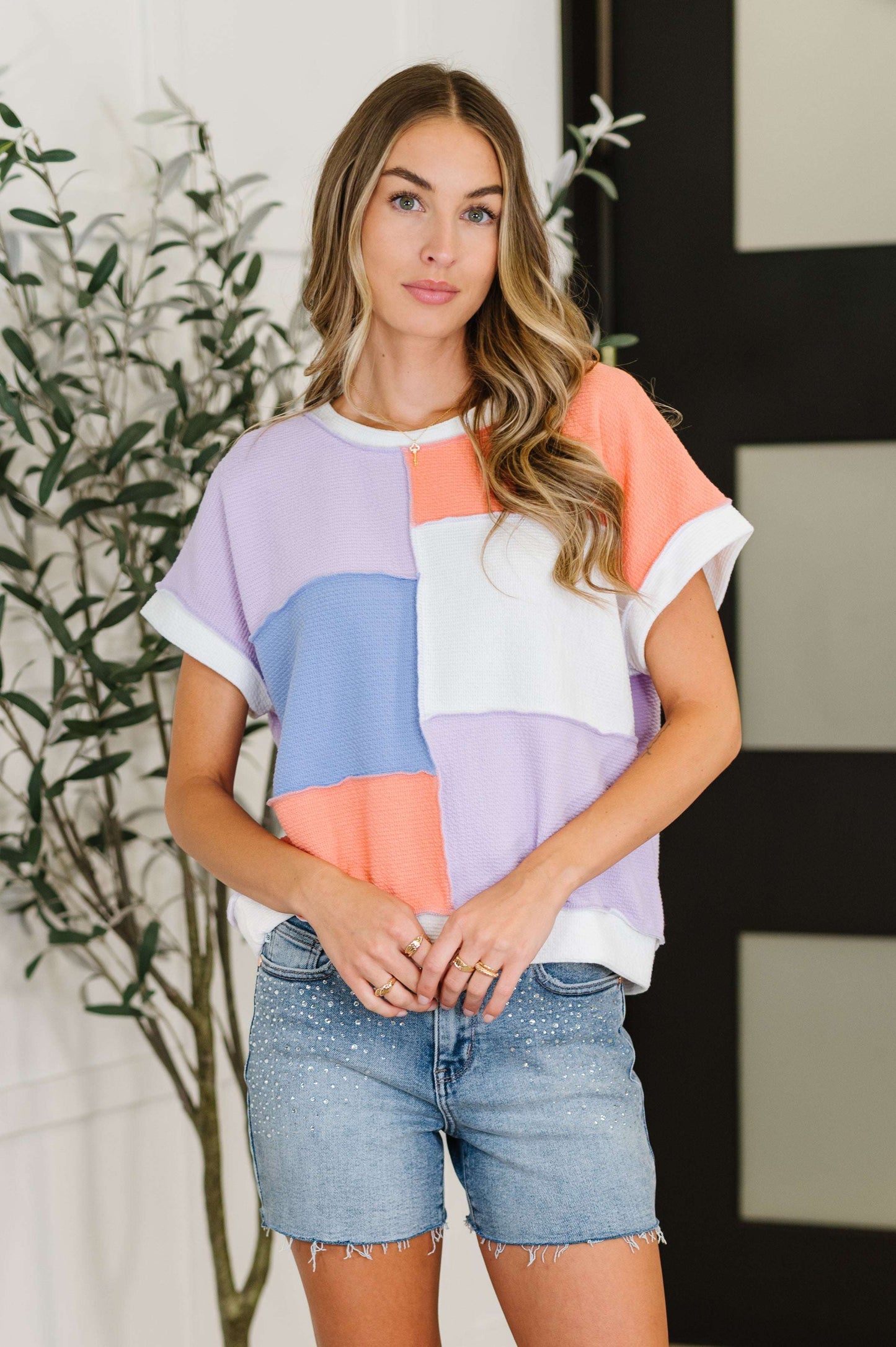 Model wearing the Contrast Club Color Block Top in lilac, orange, and denim