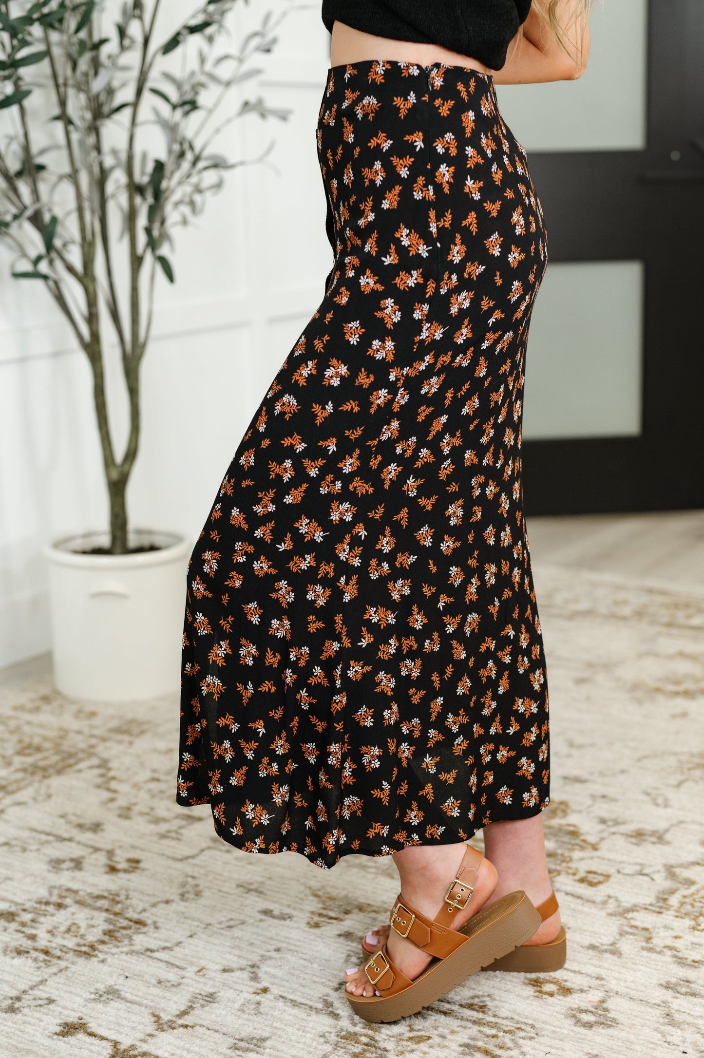 Model wearing floral button front midi skirt in rust, white, and black with platform sandals