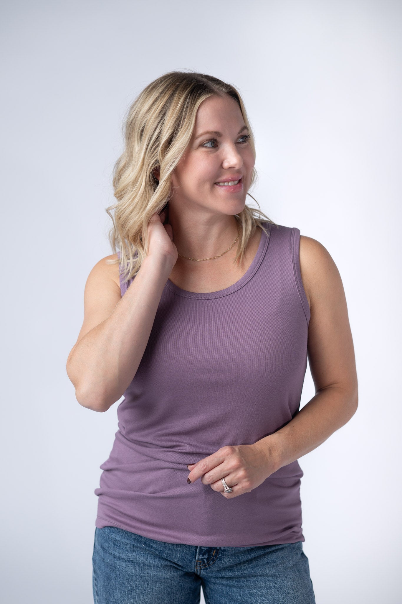 Woman wearing a dusty lavender Ava Tank with scoop neckline and micro ribbed fabric, paired with jeans