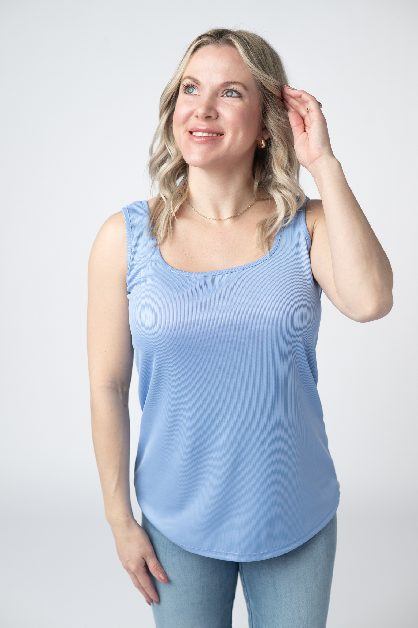  Woman wearing a sky blue Rachel Ribbed Tank with scoop neck and curved hem in lightweight ribbed fabric