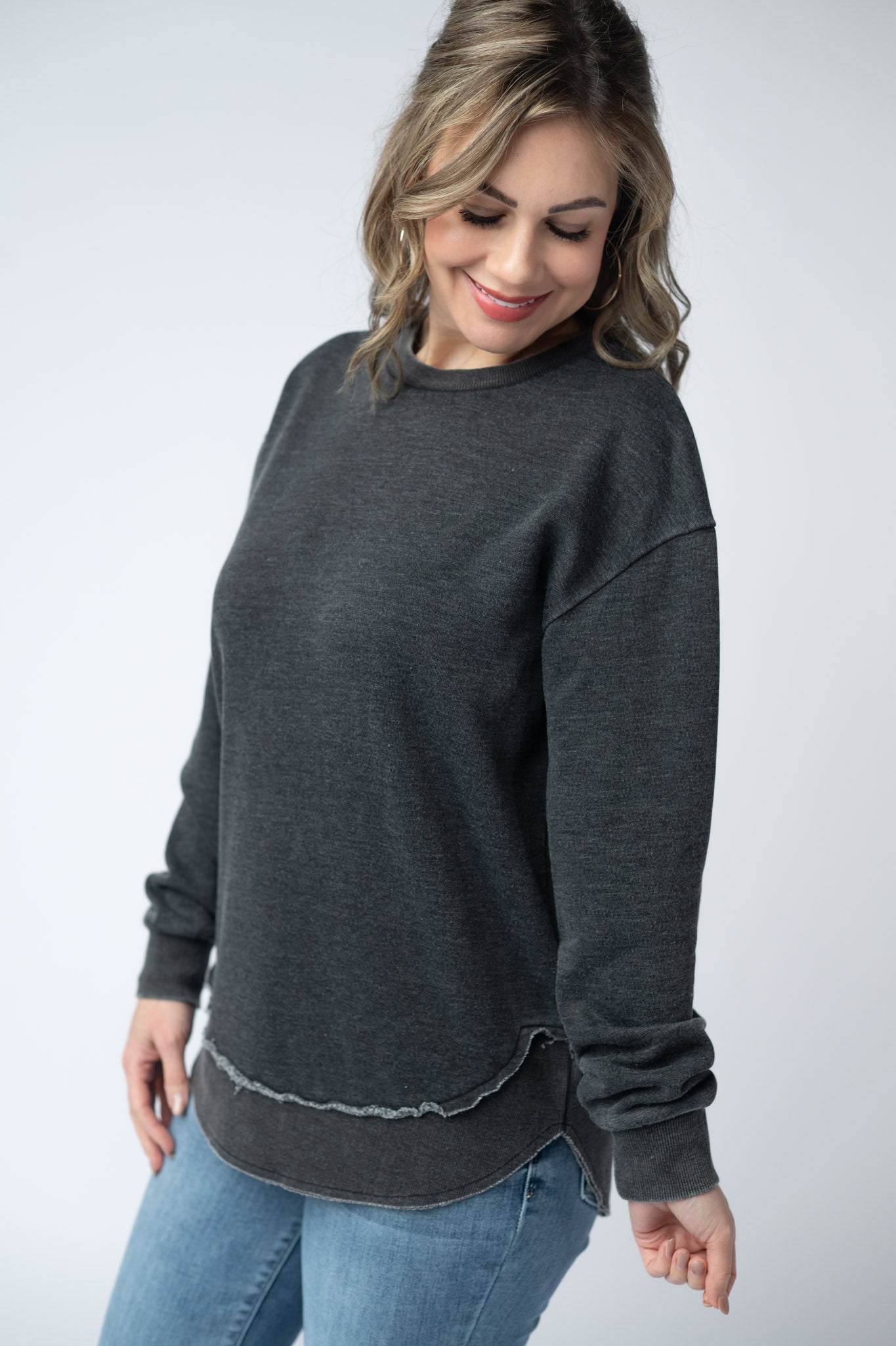 Women's vintage wash pullover in Black with crew neck, relaxed fit, and raw edge hem details