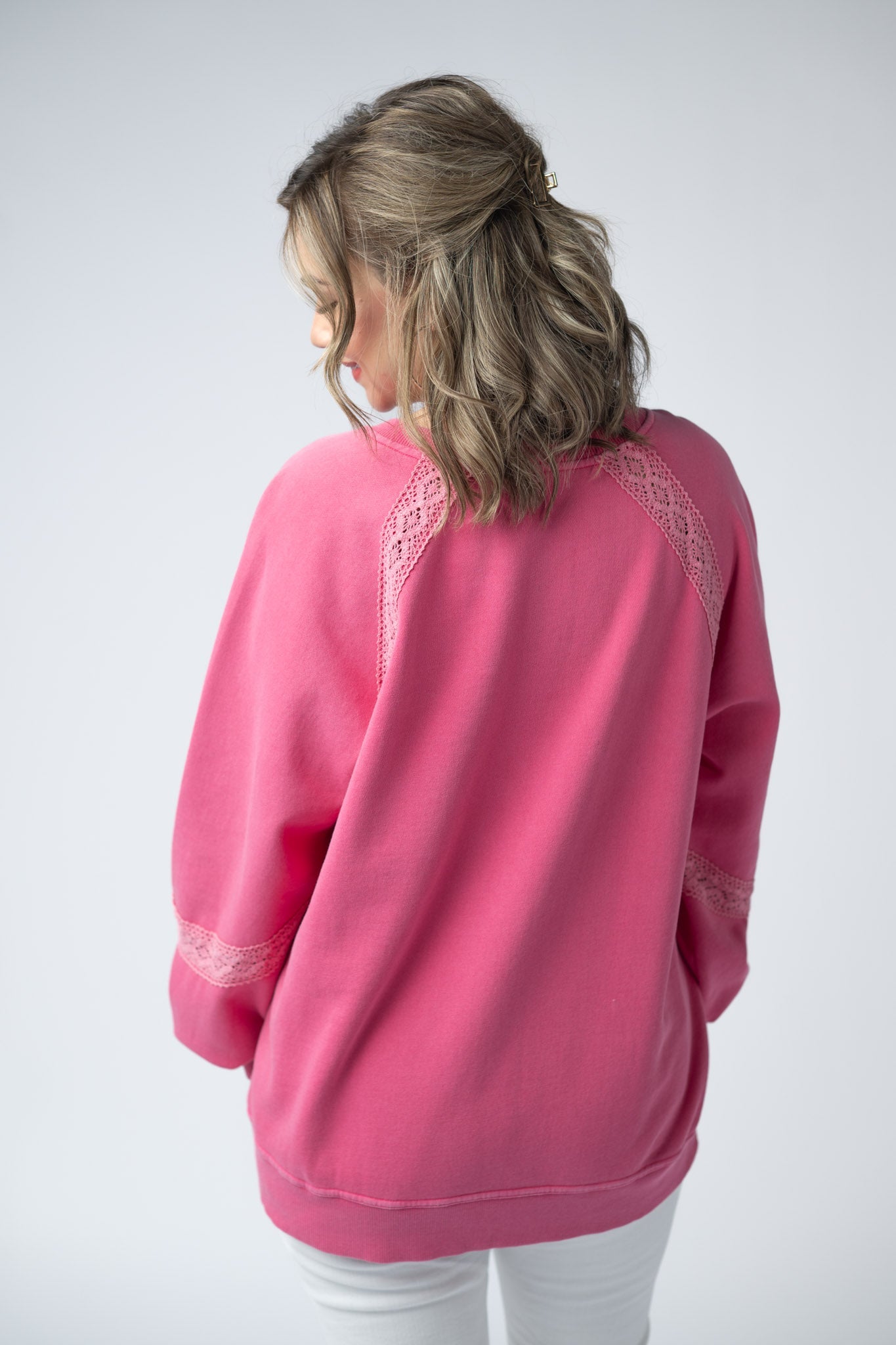 Women's lace accent vintage wash pullover in Hot Pink with notch neckline, lace shoulder and sleeve details, and relaxed fit