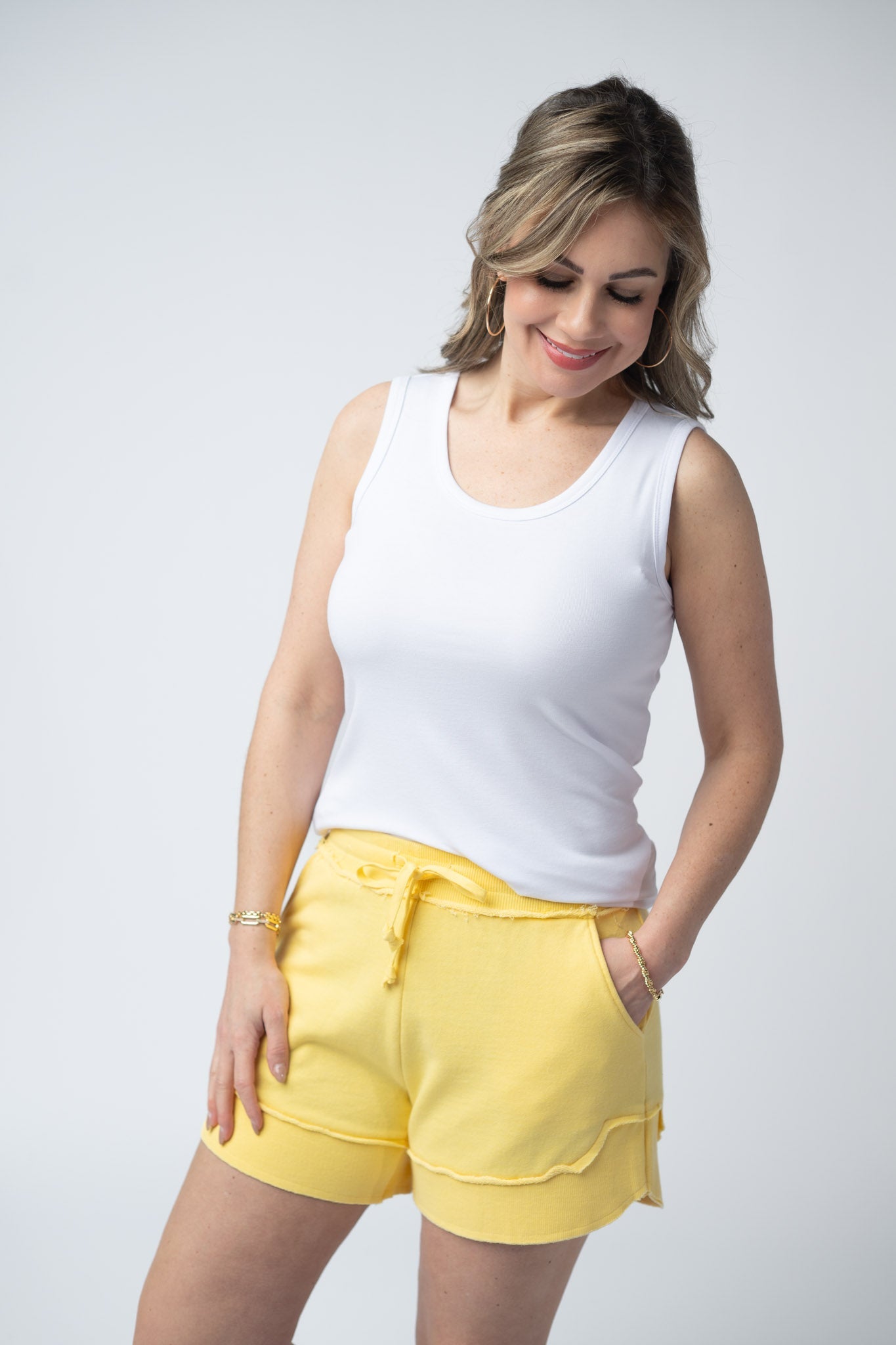 Women's French terry shorts in Lemon with drawstring waist, side pockets, raw edge details, and side scoop hem