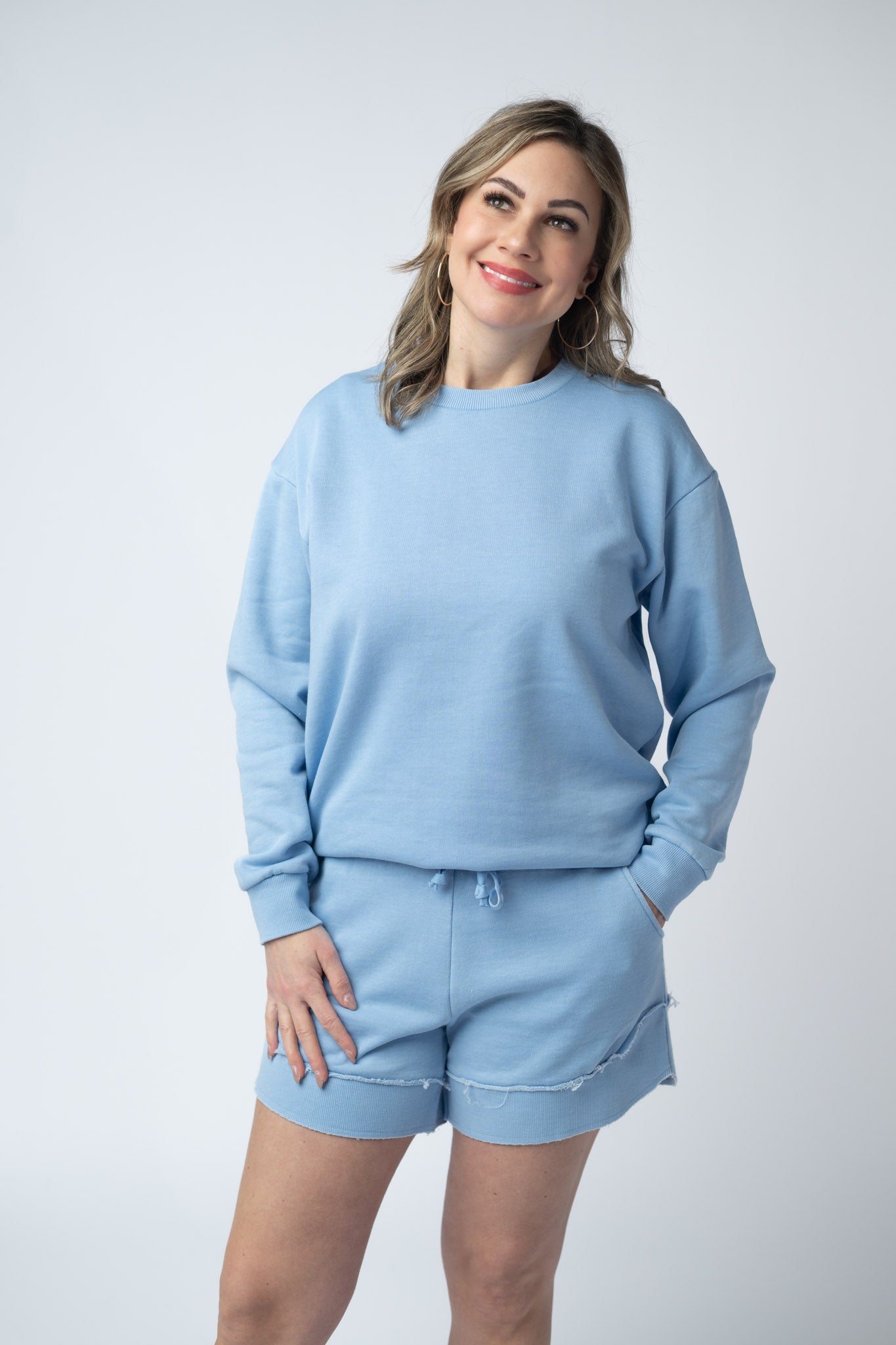 Women's vintage wash pullover in Dusty Blue with crew neck, relaxed fit, and raw edge hem details