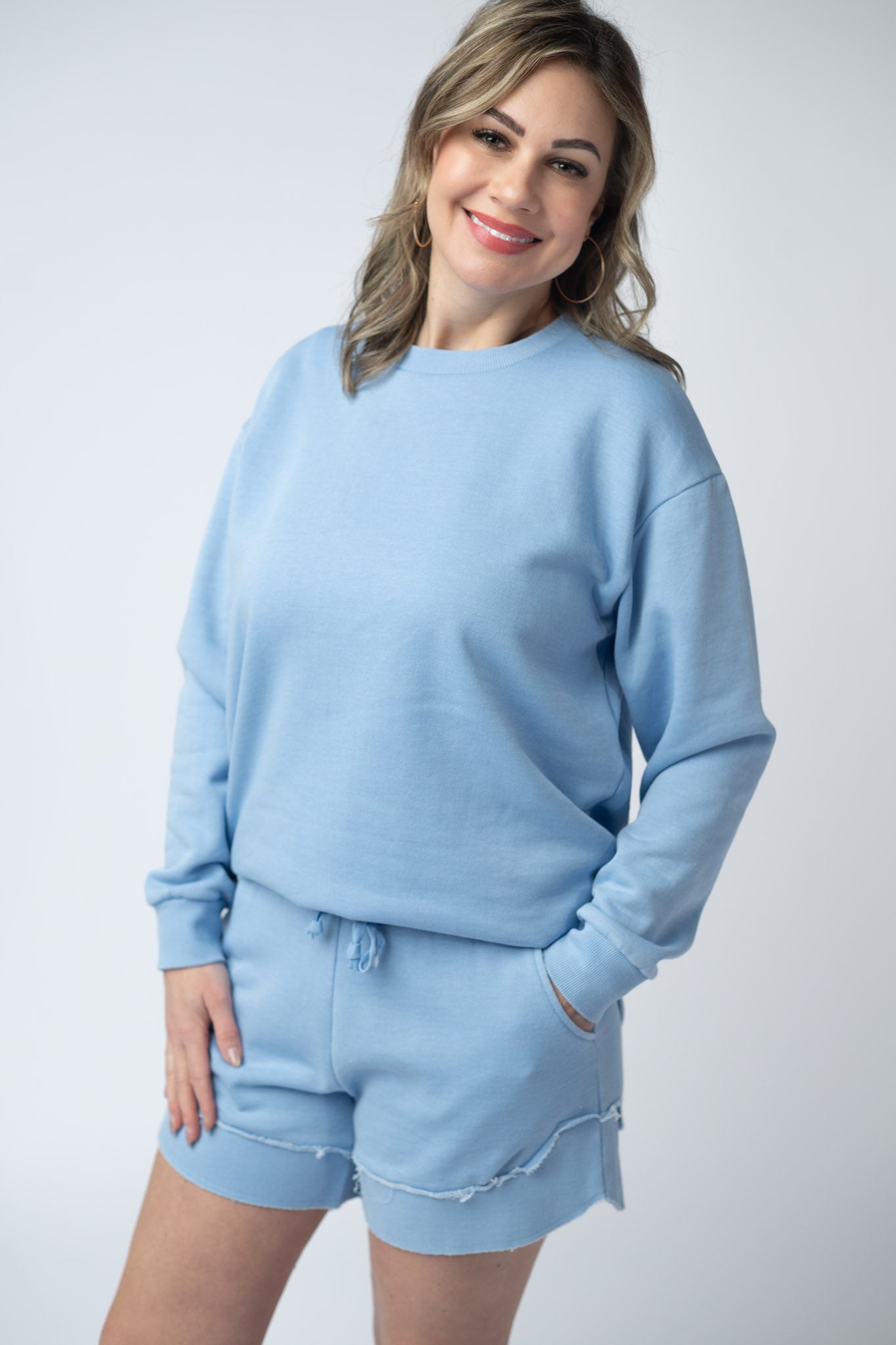 Women's vintage wash pullover in Dusty Blue with crew neck, relaxed fit, and raw edge hem details