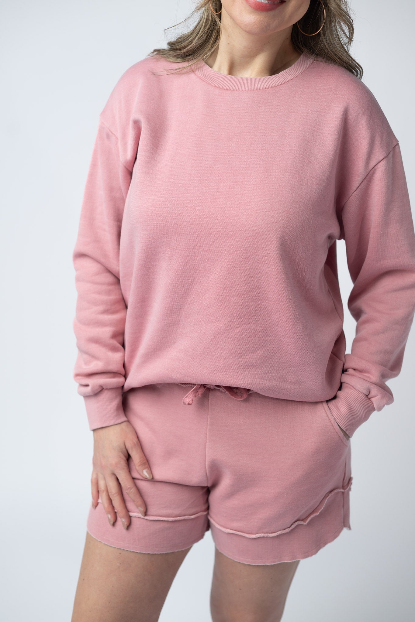 Women's vintage wash pullover in Dusty Pink with crew neck, relaxed fit, and raw edge hem details