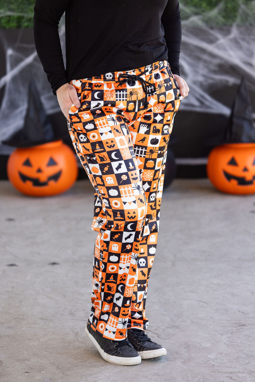 Halloween lounge pants in orange, black, and white trick-or-treat checkered print with pockets