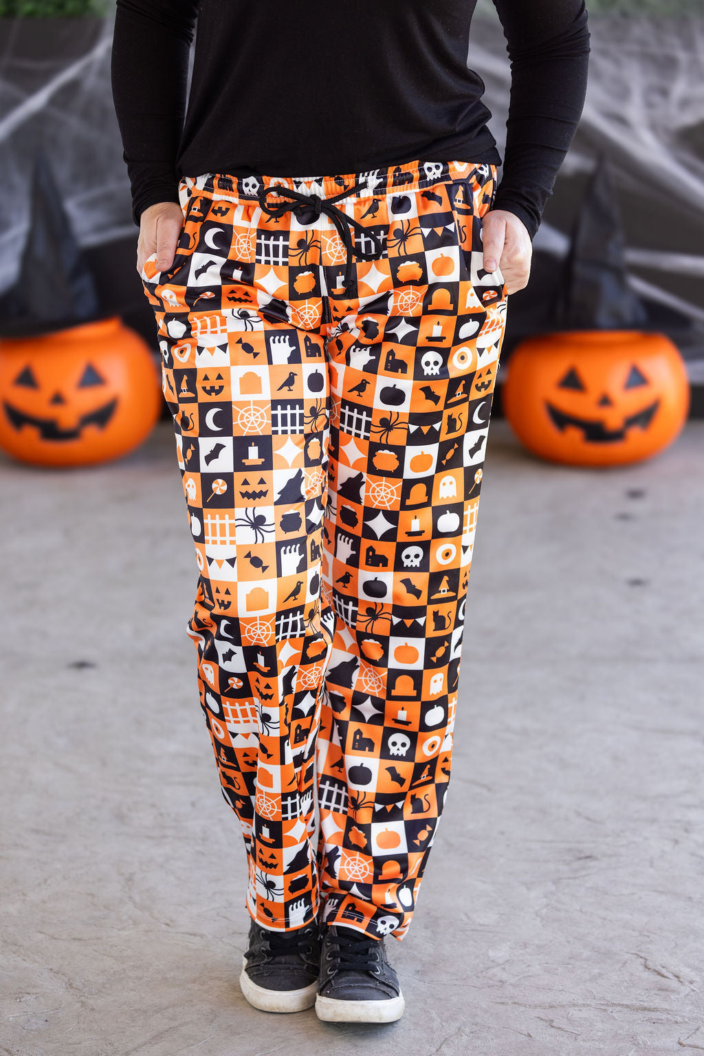 Halloween lounge pants in orange, black, and white trick-or-treat checkered print with pockets