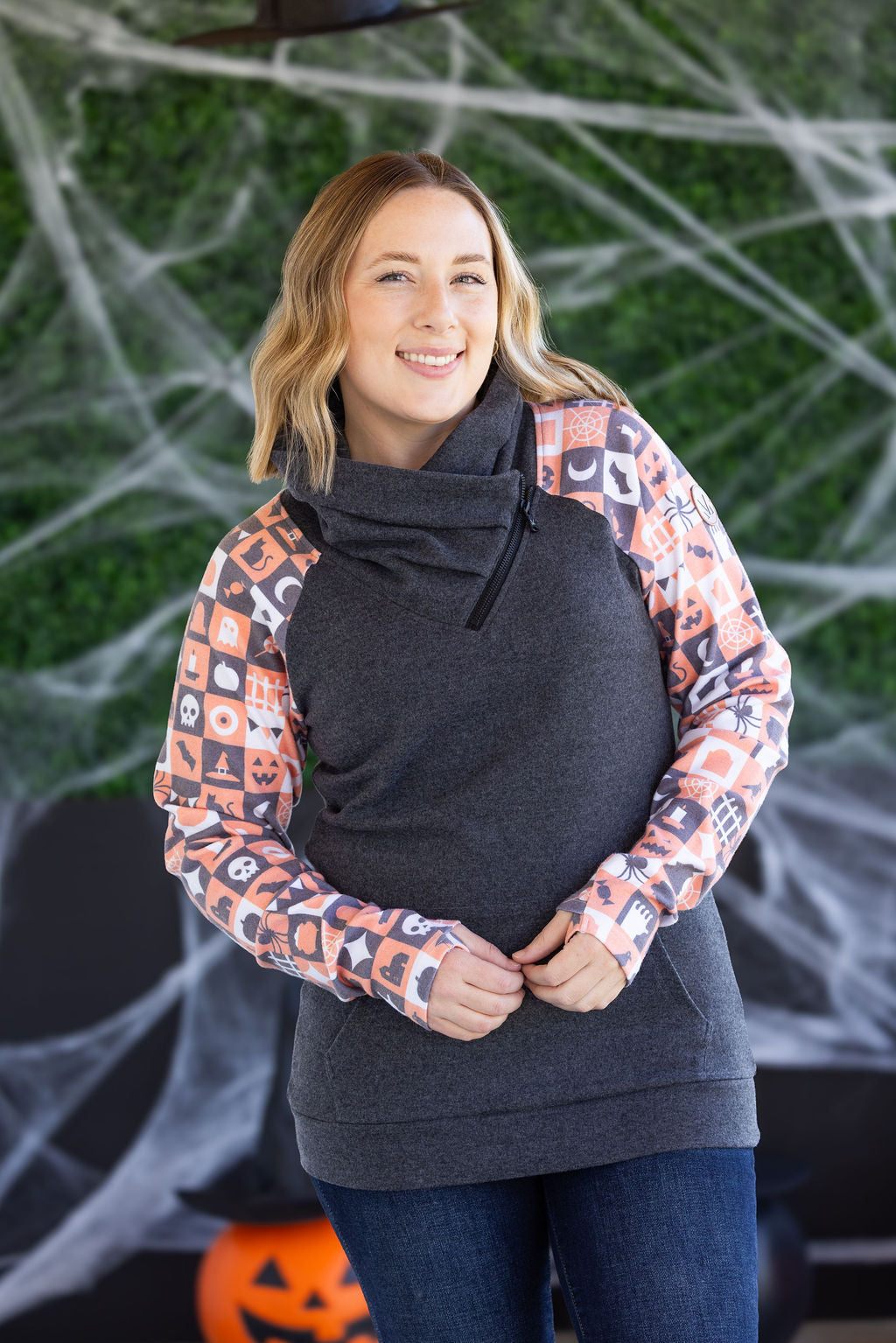 Zoey ZipCowl Sweatshirt in Trick or Treat with orange-and-black checkered sleeves