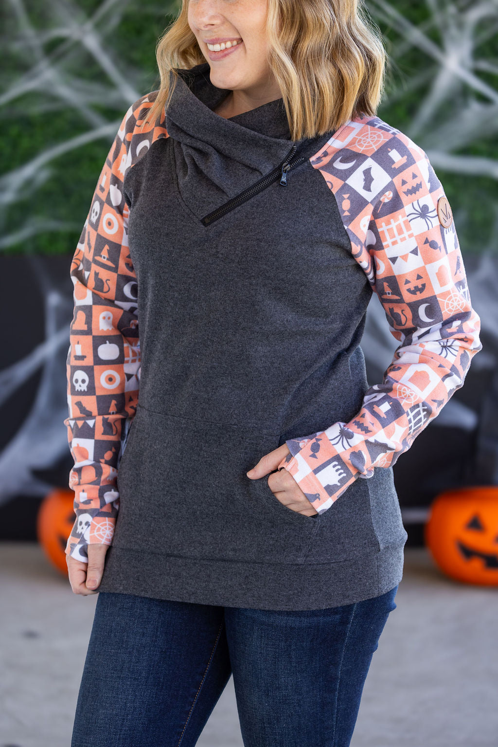 Zoey ZipCowl Sweatshirt in Trick or Treat with orange-and-black checkered sleeves