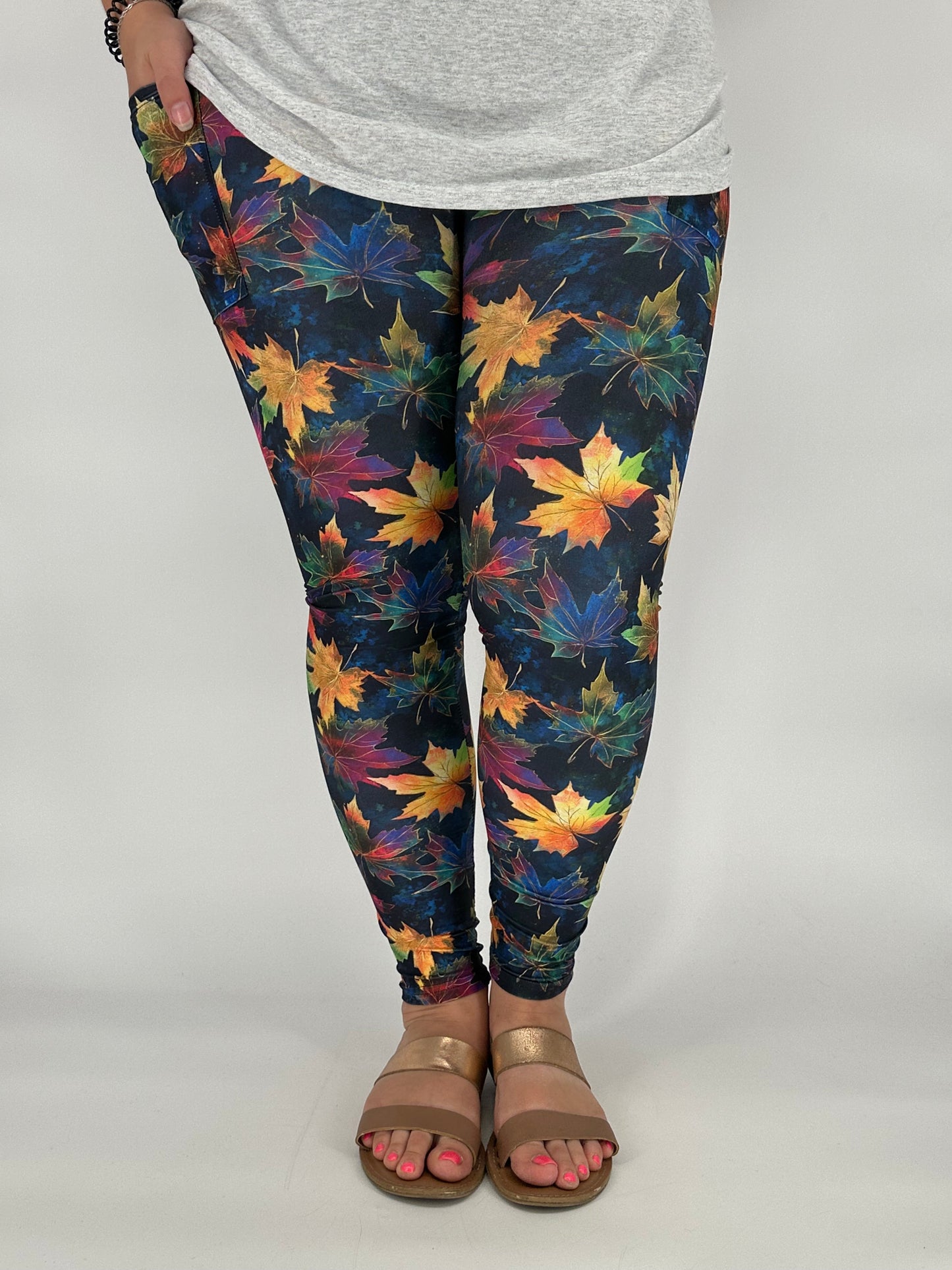 Person wearing colorful leaf-patterned leggings on a plain background