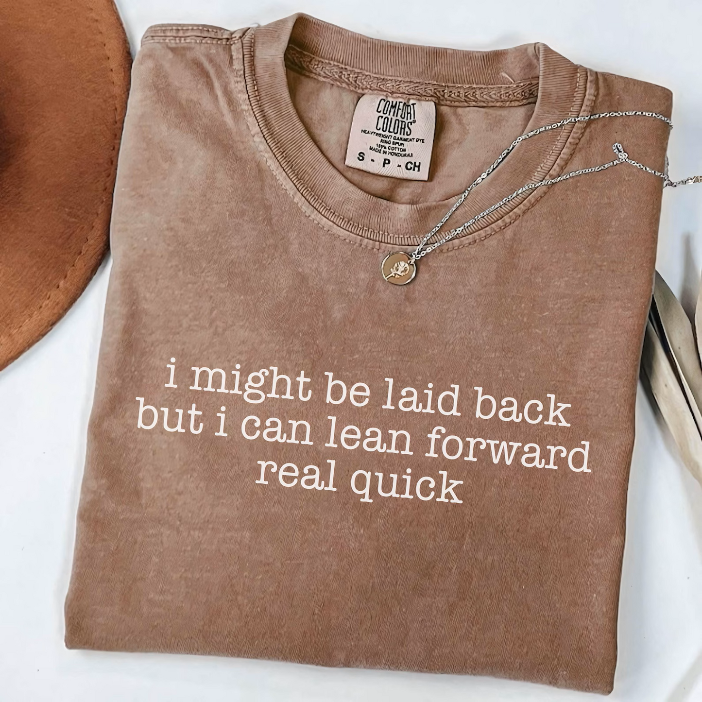 "I might be laid back but I can lean forward real quick" graphic tee. Comfort Colors garment-dyed cotton, relaxed fit. Sizes S-4XL. Alaska boutique.