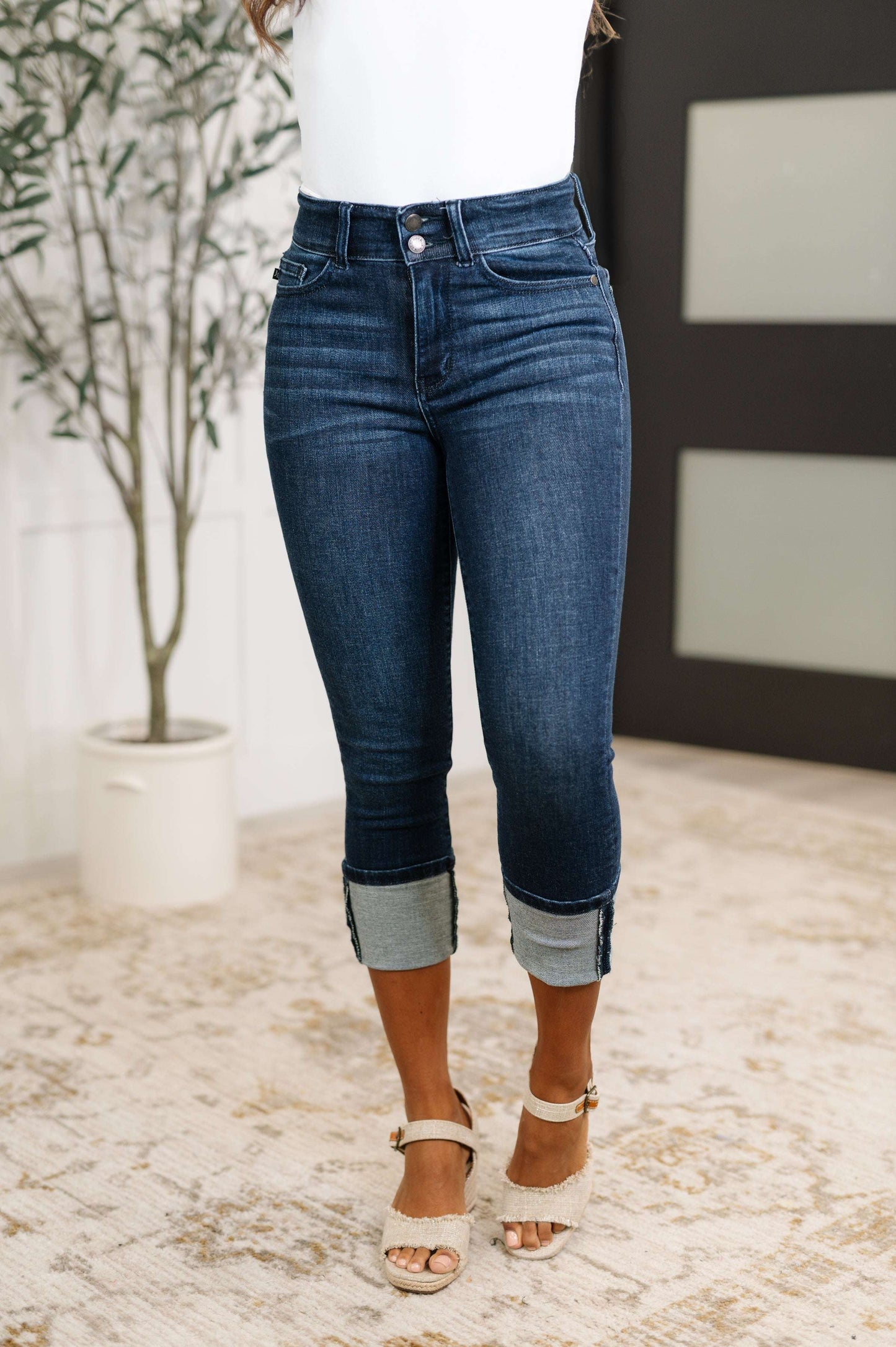 Model wearing Karen High Rise Double Waist Band Capri Jeans in dark wash with optional cuffed hem