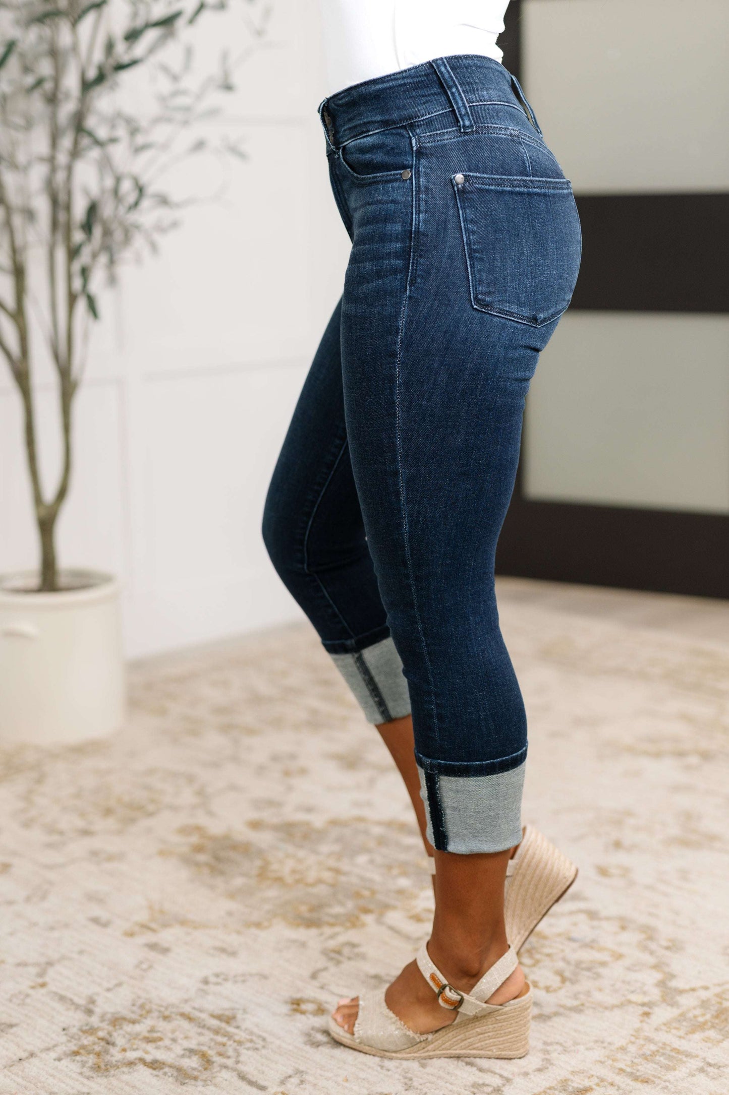 Model wearing Karen High Rise Double Waist Band Capri Jeans in dark wash with optional cuffed hem