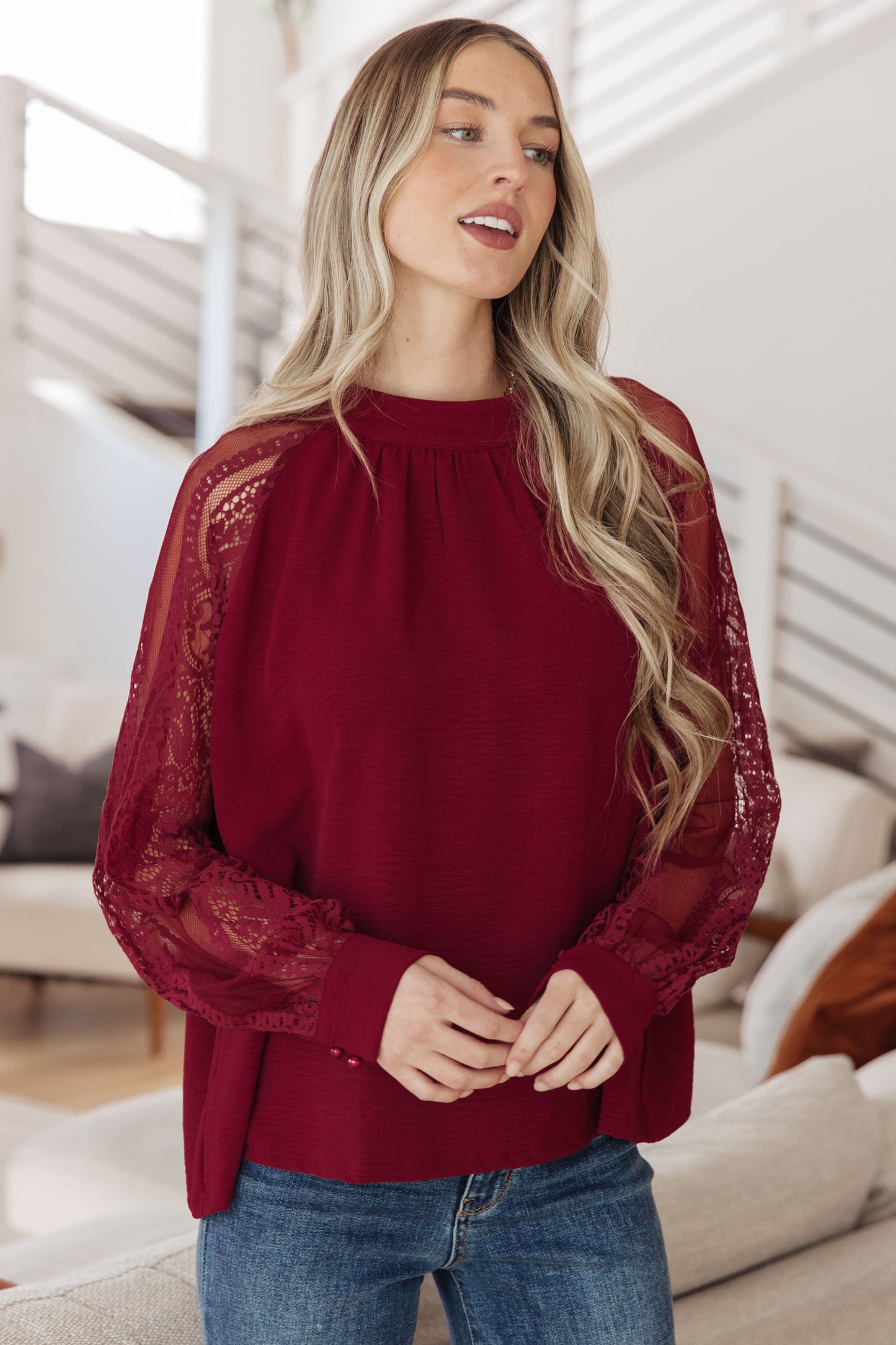 Burgundy lace sleeve blouse with crinkle woven bodice, mock neckline, and sheer lace long sleeves