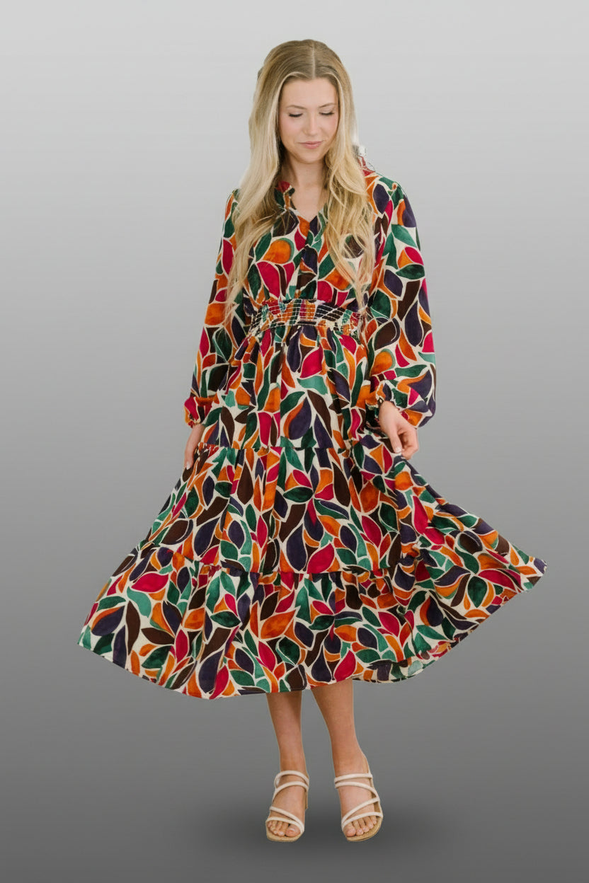 Woman is wearing a bright floral dress, with black, red, and green leaf designs on a white background.