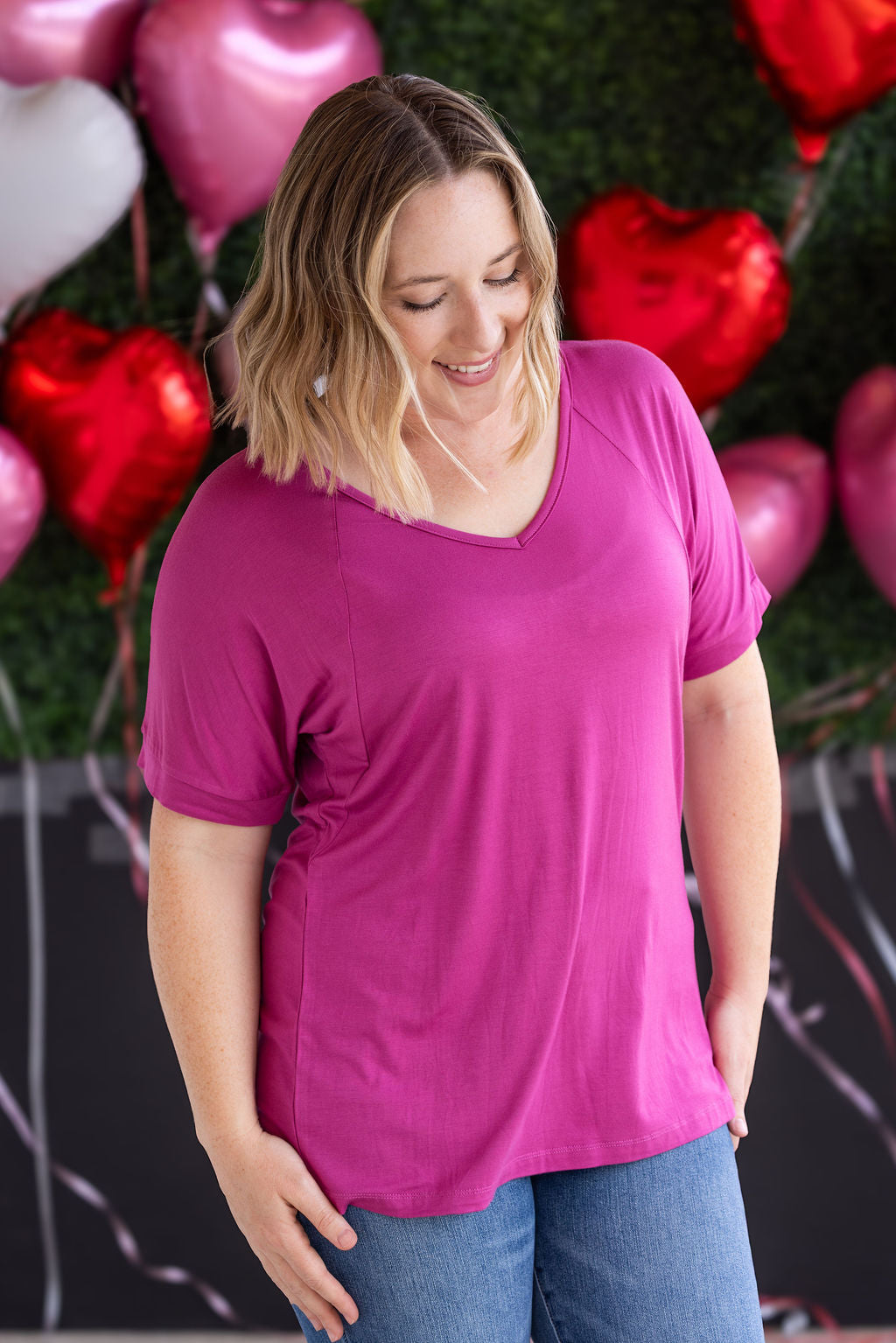 Woman wearing magenta v-neck t-shirt with relaxed fit and cuffed short sleeves in soft bamboo fabric