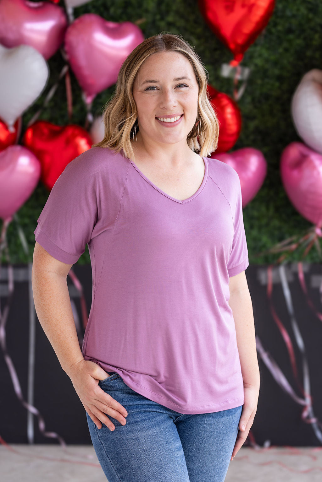 Woman wearing dusty pink v-neck t-shirt with relaxed fit and cuffed short sleeves in soft bamboo fabric