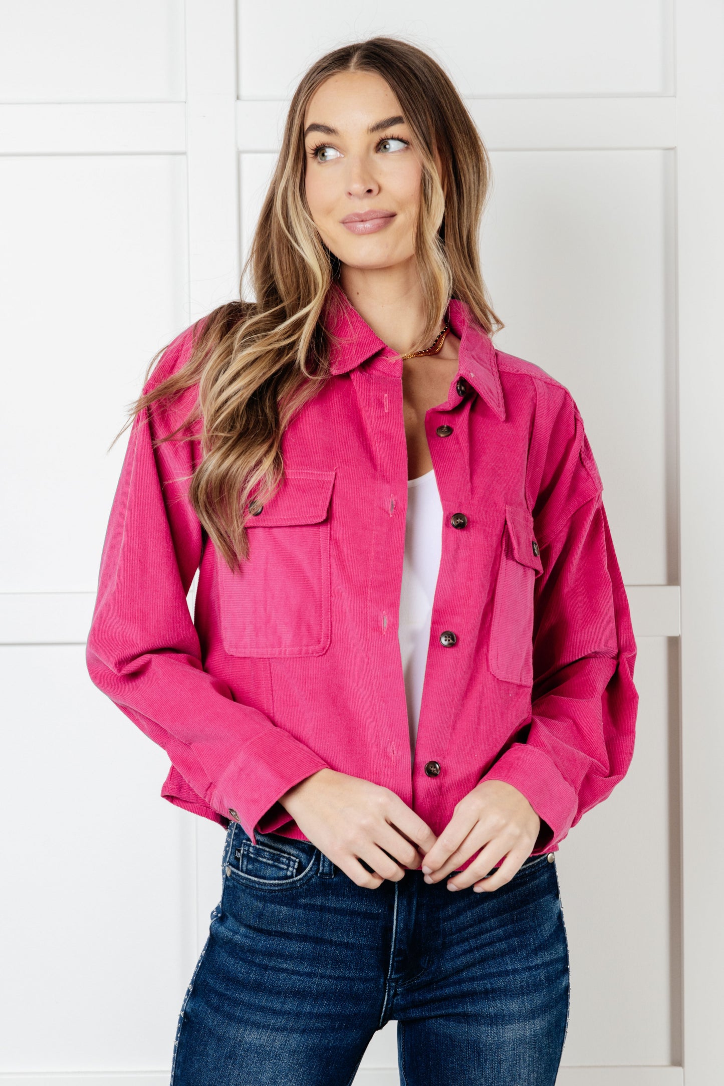 Woman wearing a very pink lightweight corduroy jacket featuring patch pockets, a button front, and a boyfriend fit.
