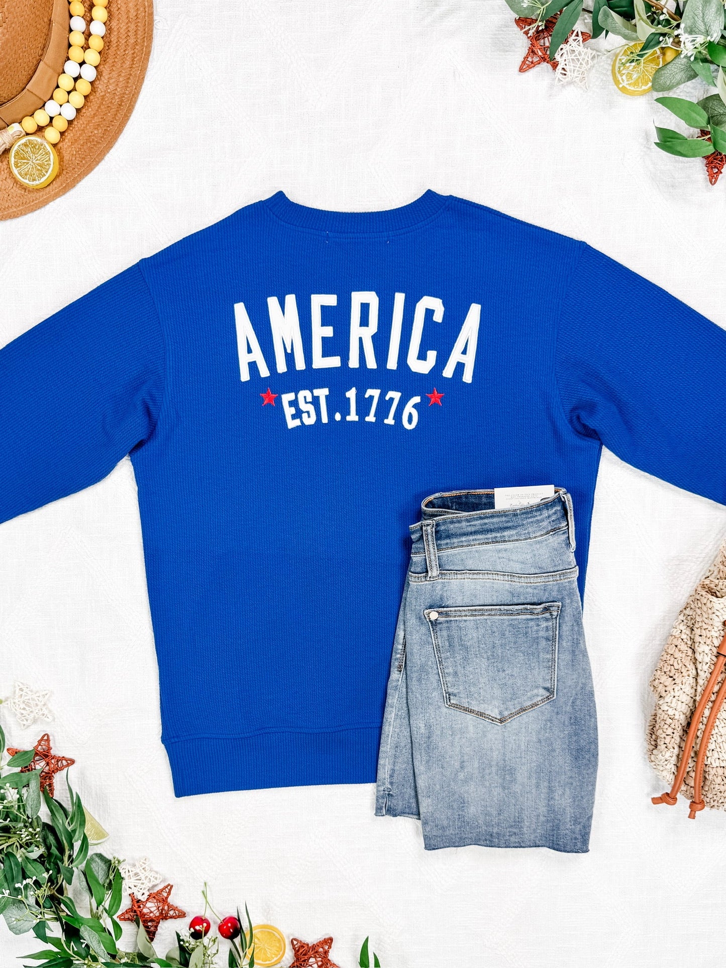 Blue sweatshirt with 'AMERICA EST. 1776' text on a white background