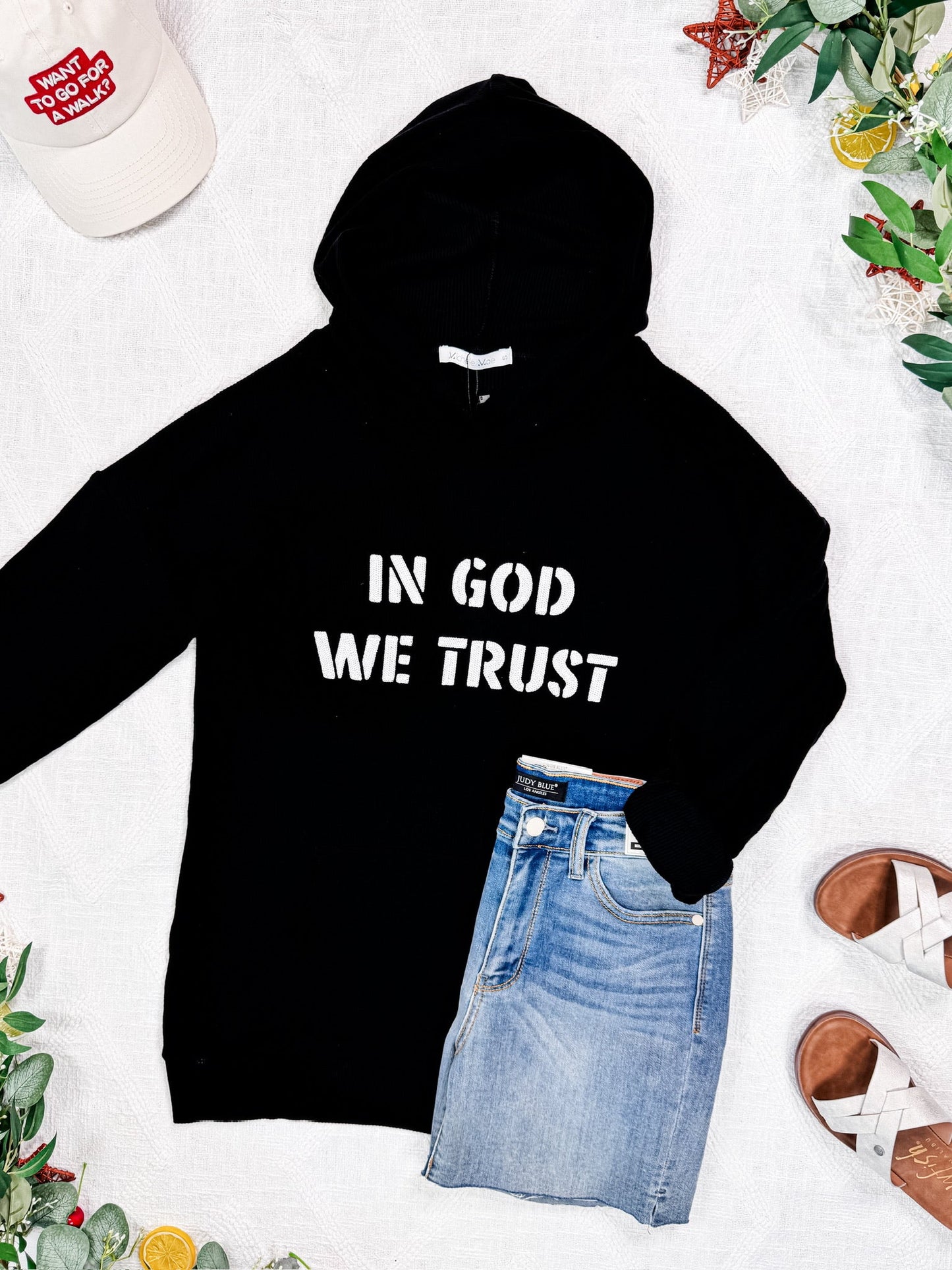Corrine Embroidered Hoodie in black with “In God We Trust” design, kangaroo pocket, and cuff sleeves.