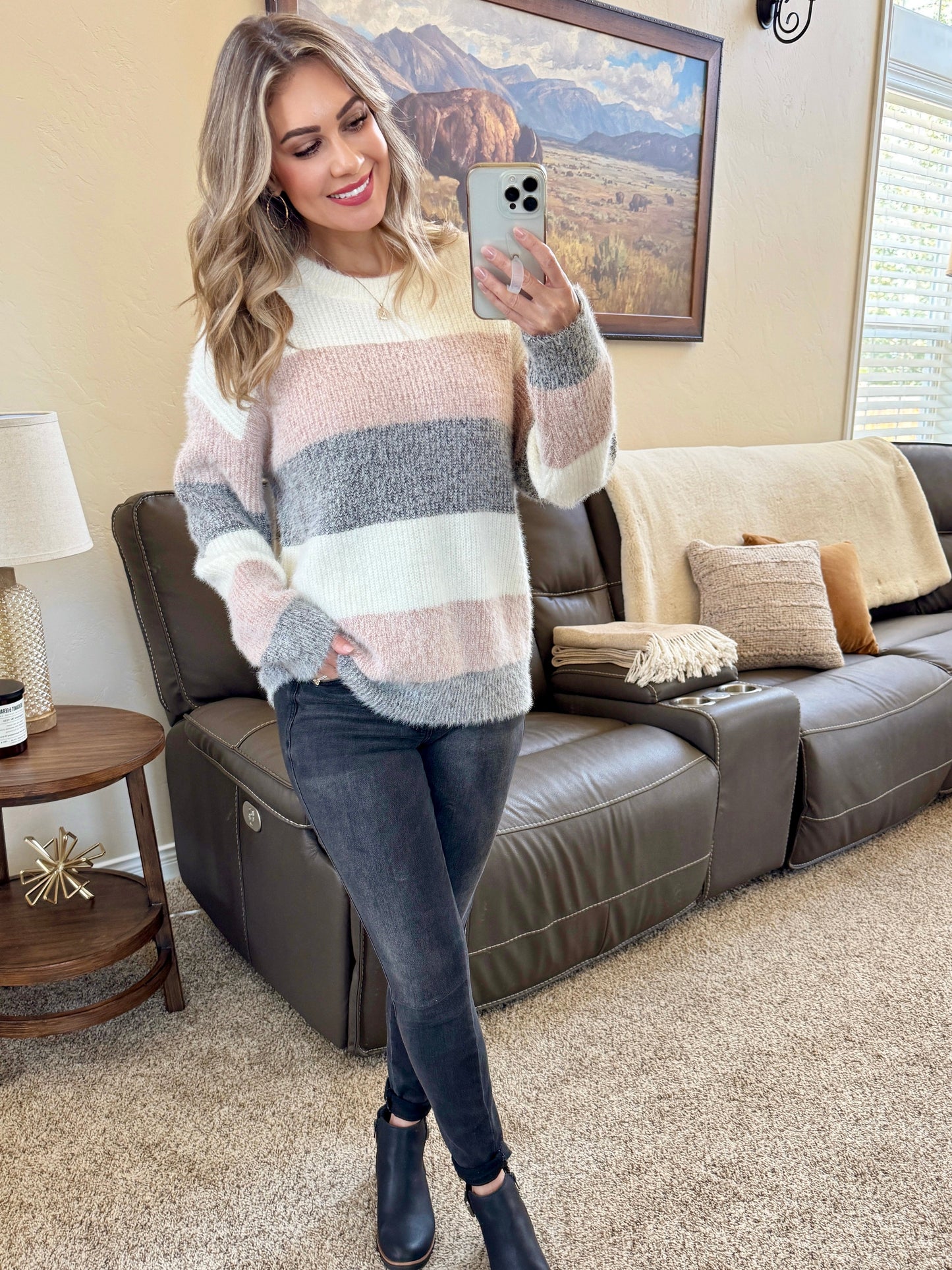 Woman wearing ultra-soft fuzzy colorblock sweater with ivory, blush pink, and gray stripes and crew neckline