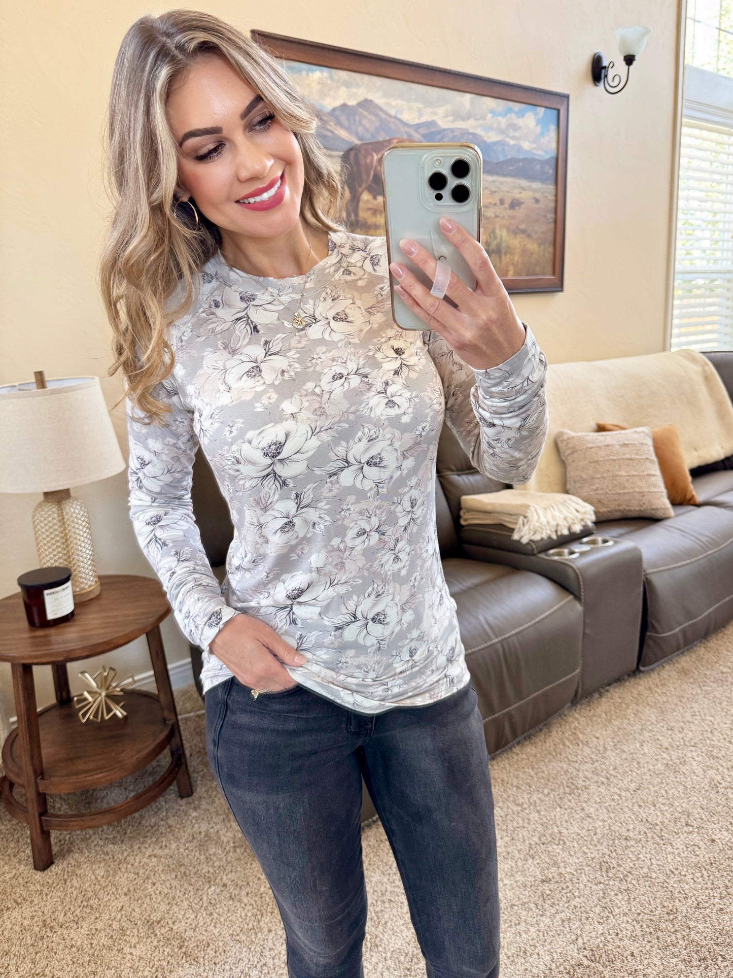 Woman wearing gray fitted long sleeve top with vintage floral print and high neckline