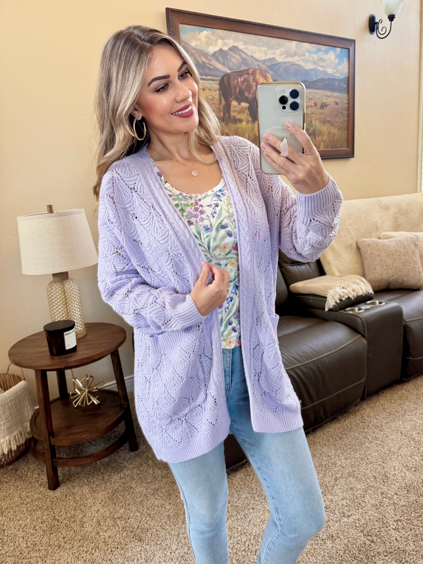 Woman wearing a lavender Open Knit Cardigan with leaf pattern detail and pockets, layered over a floral tank and jeans