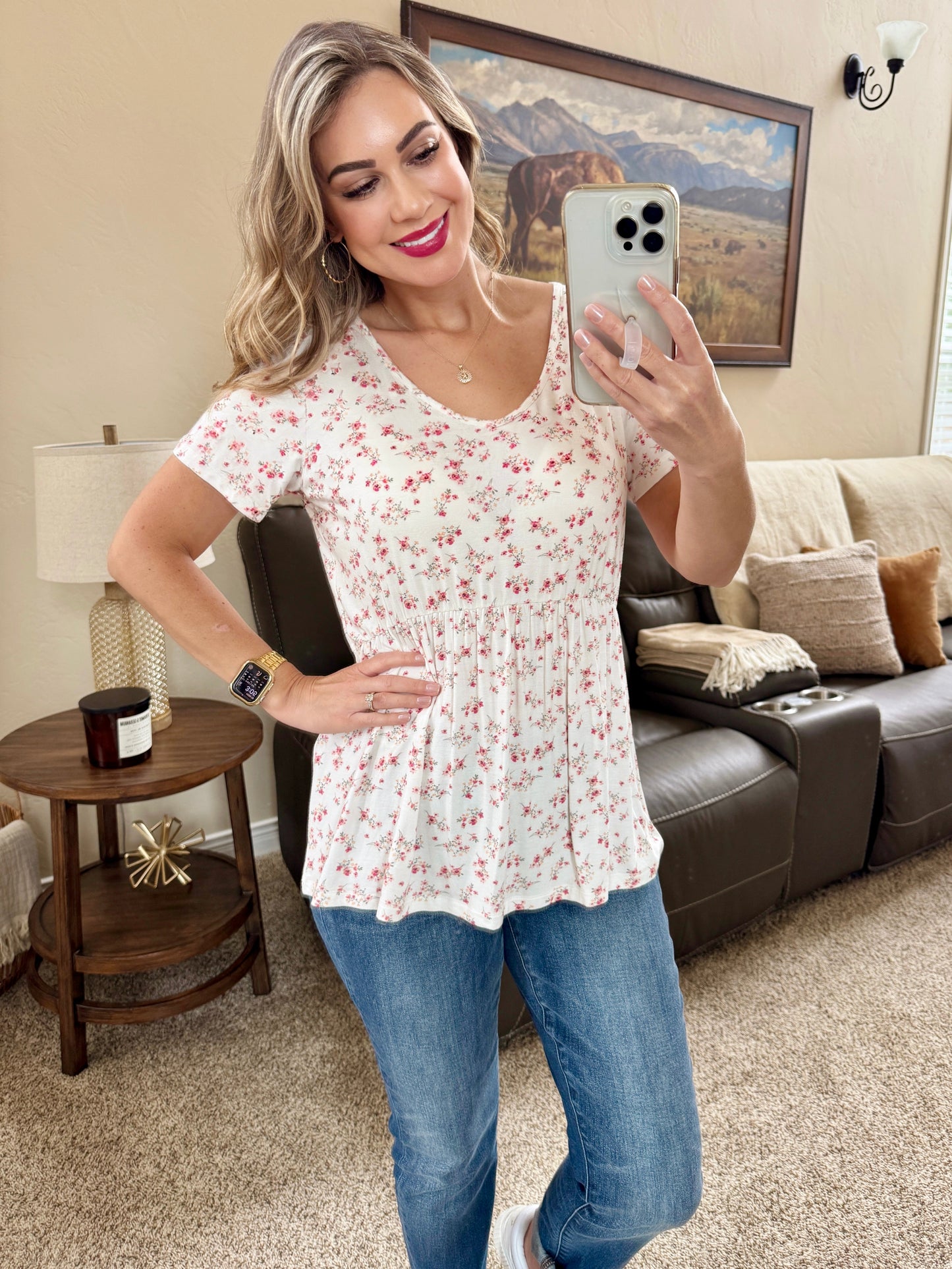 Woman wearing white babydoll top with small pink floral print and ruffle sleeves
