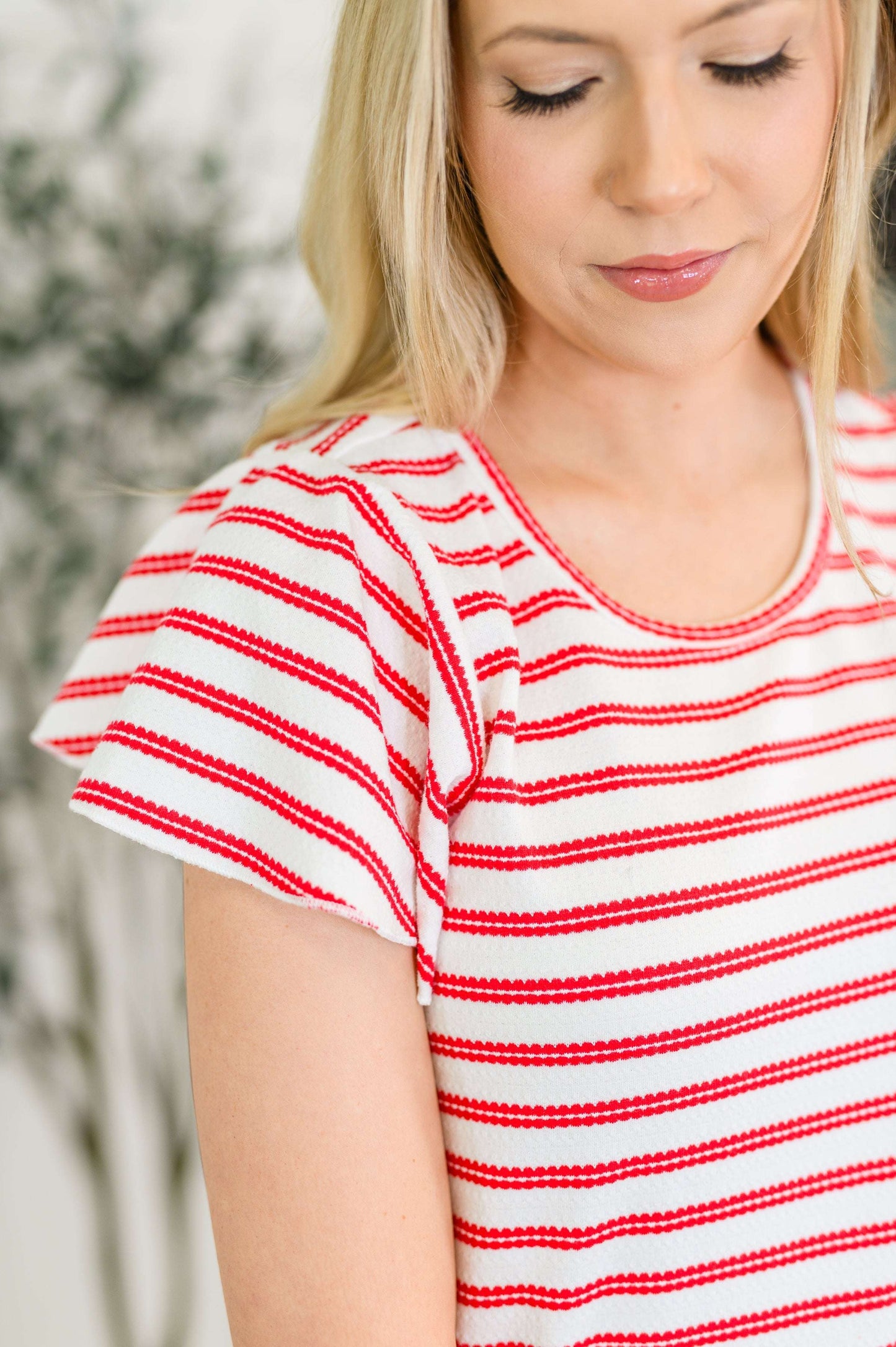 Woman wearing the Sunny Stripes Casual Flutter Sleeve Dress with red and white stripes and blue sandals
