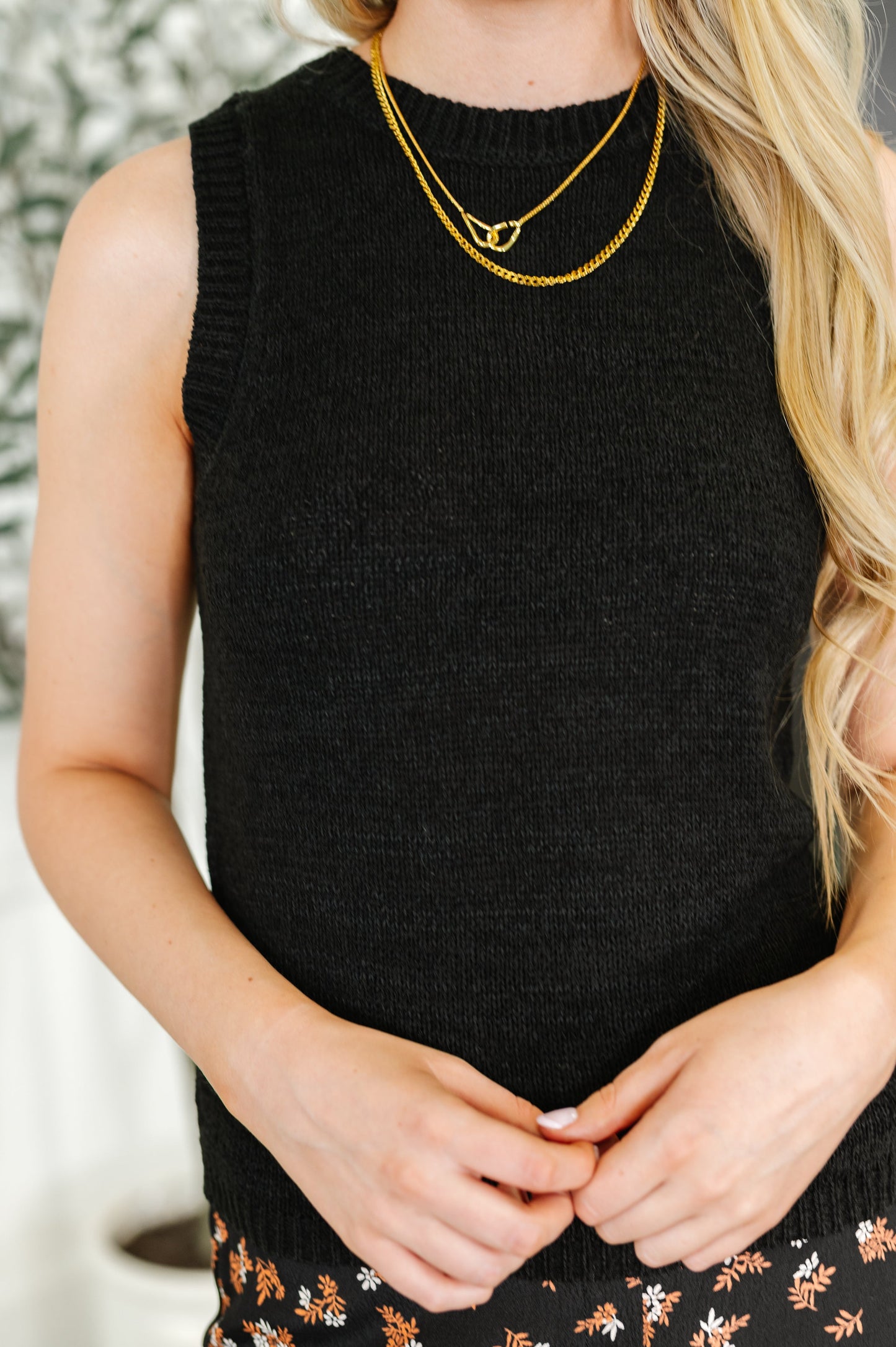 Model wearing black knit tank top with ribbed neckline and floral skirt
