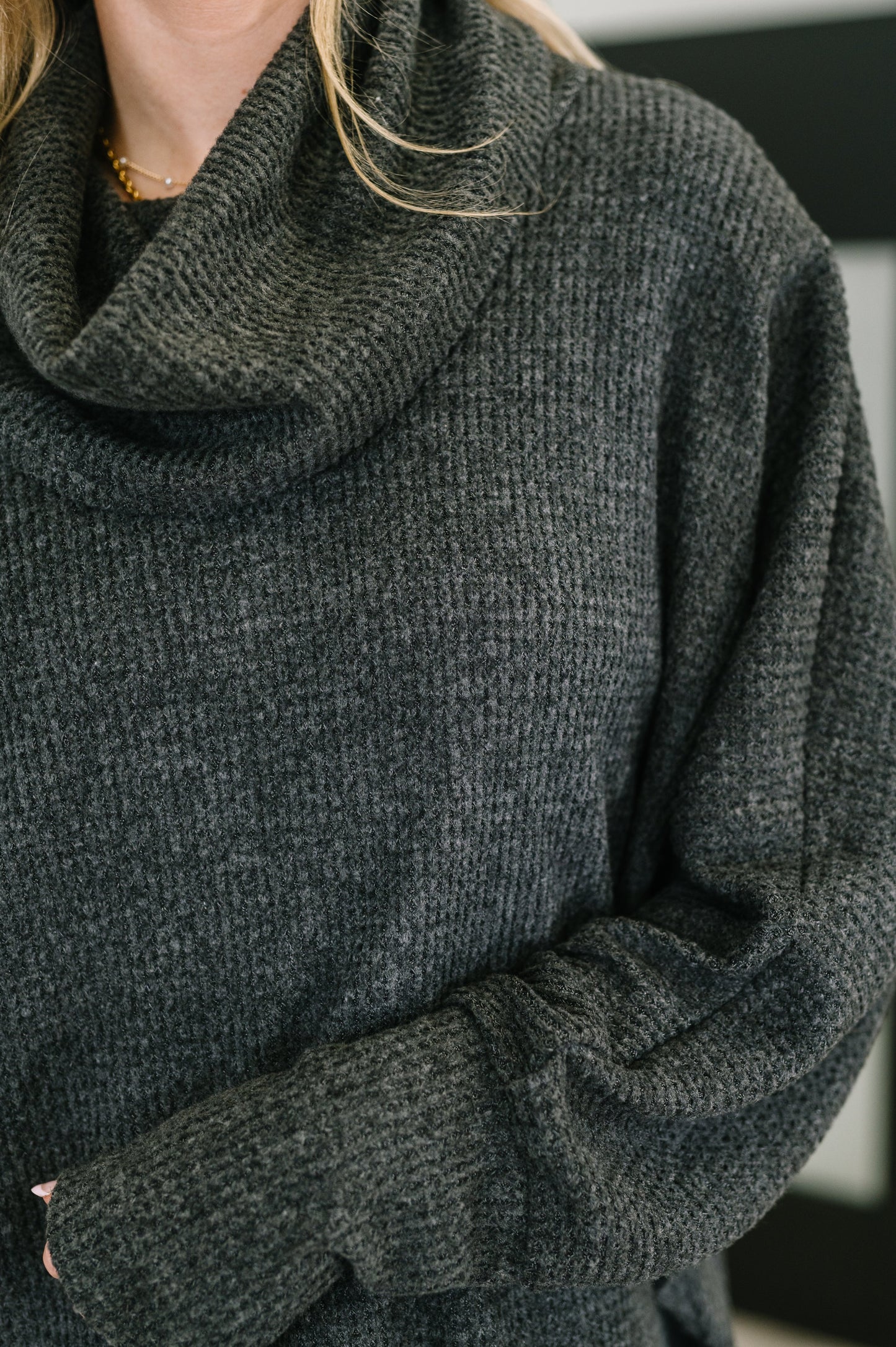Dark gray sweater with a close-up on the fabric texture.