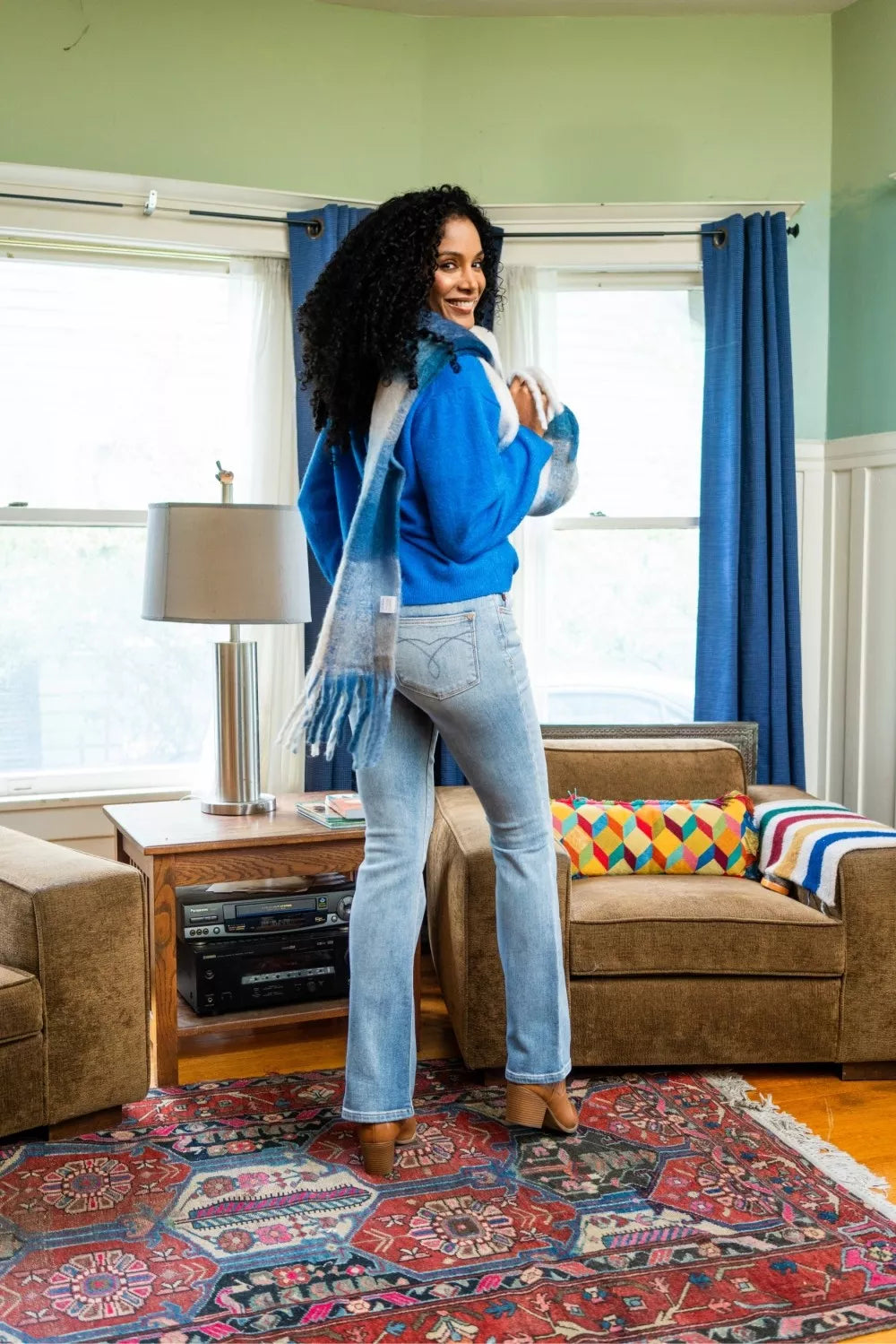 Woman wearing Aspen medium wash thermal bootcut jeans with mid-rise fit and slight flare at hem