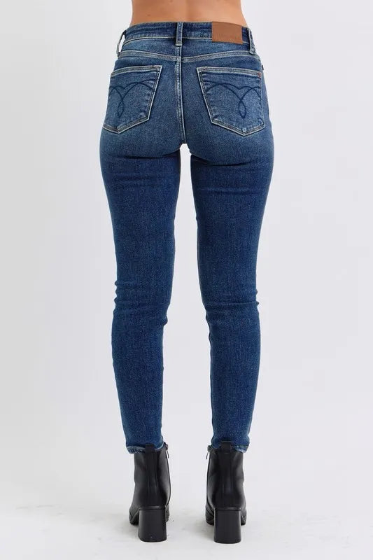 Woman wearing Kinsley dark wash mid rise thermal skinny jeans with ankle length and sleek fit