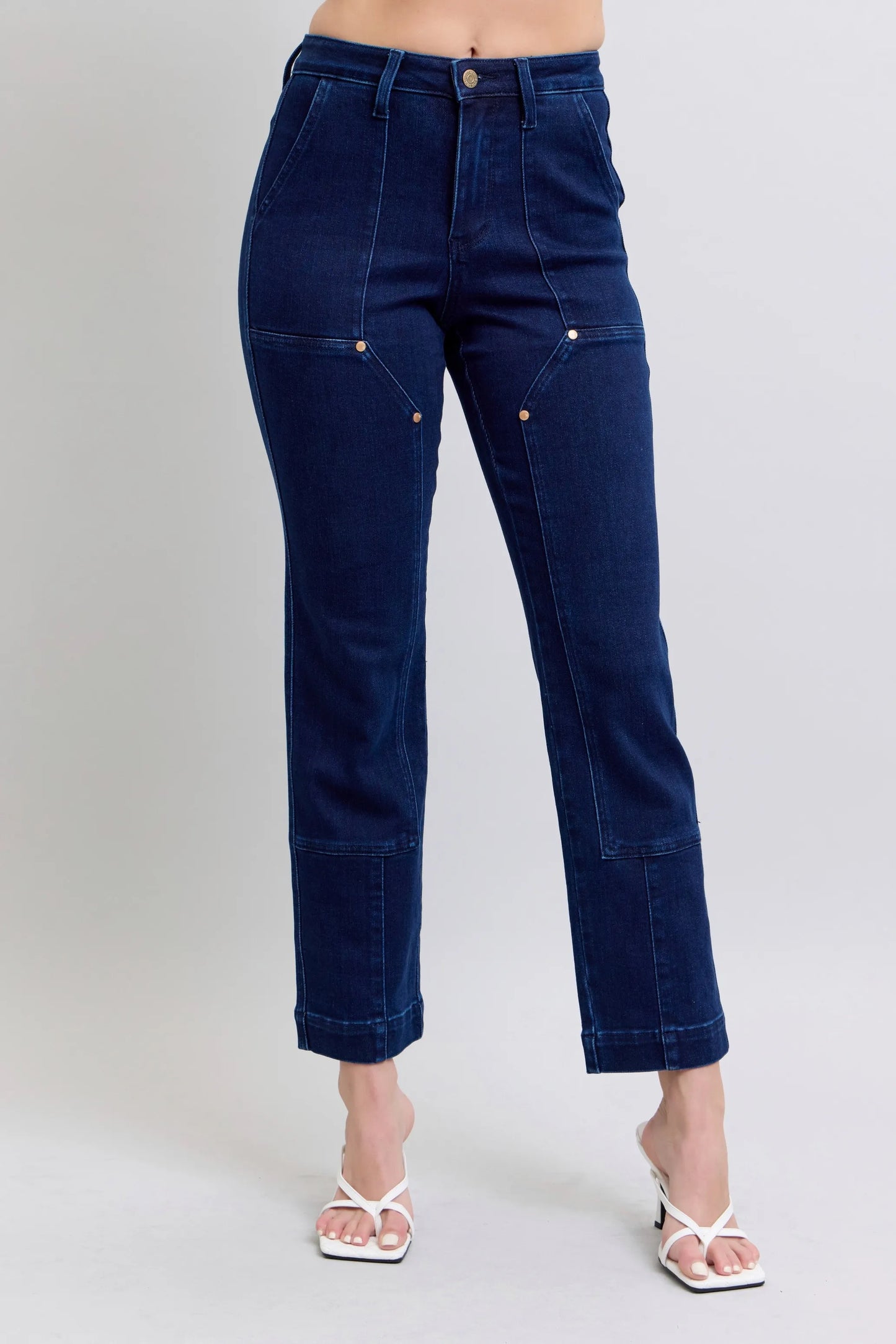Woman wearing Rowan deep indigo high rise straight leg jeans with star stud details and contrast stitching