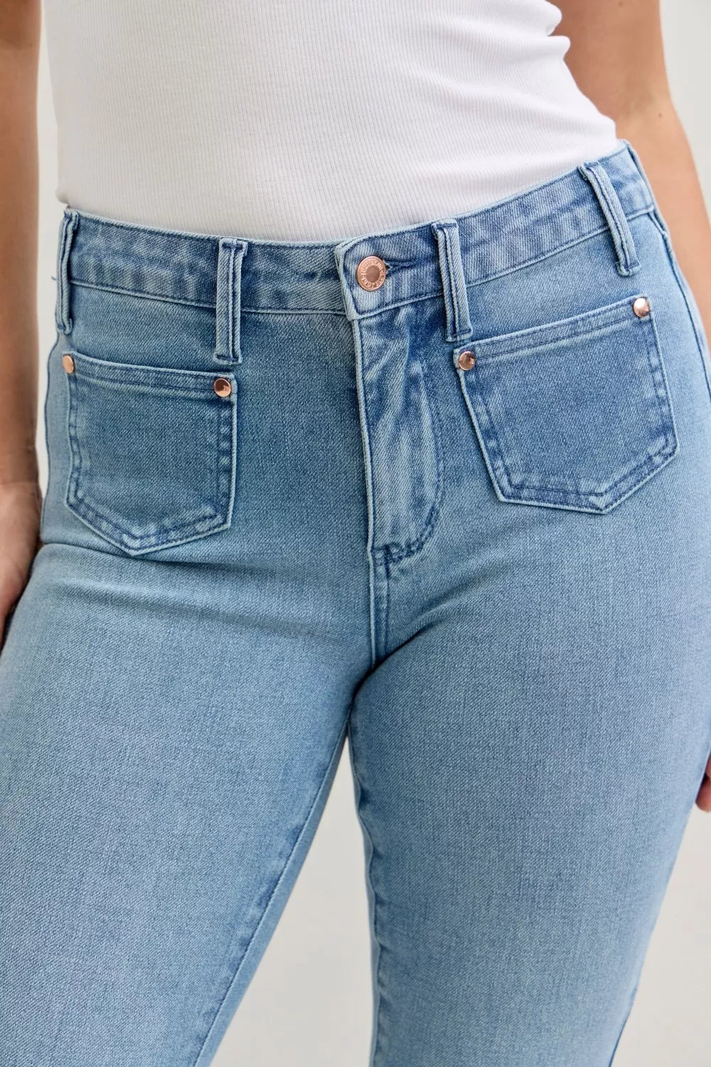 Woman wearing Marlow contrast wash bootcut jeans with distinctive front patch pockets and mid-rise fit