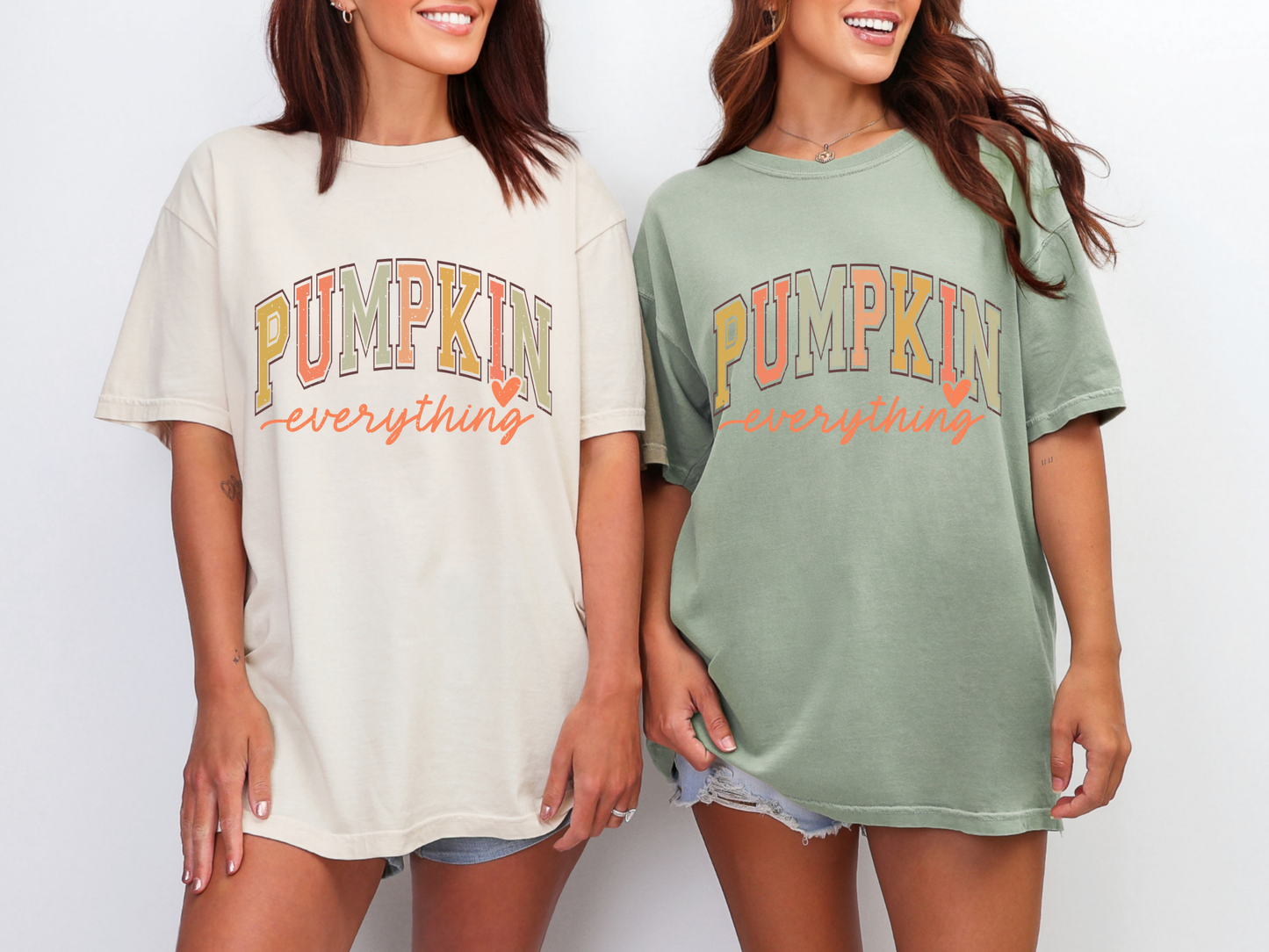 Models wearing an ivory Pumpkin Everything and olive green Pumpkin Everything graphic tees with bold fall lettering, styled with casual shorts for a relaxed autumn look.