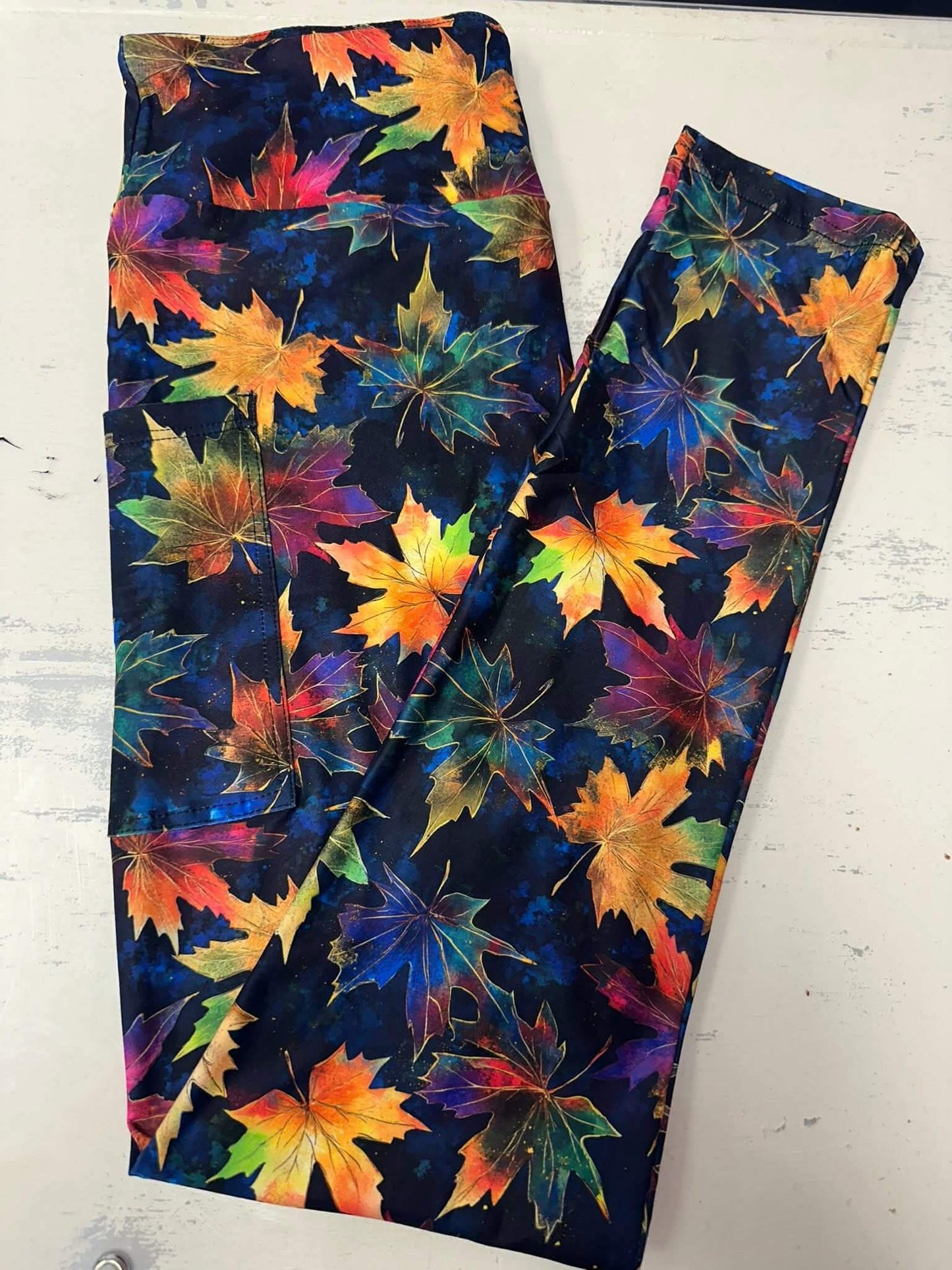 Black leggings with multicolor maple leaf print in fall colors